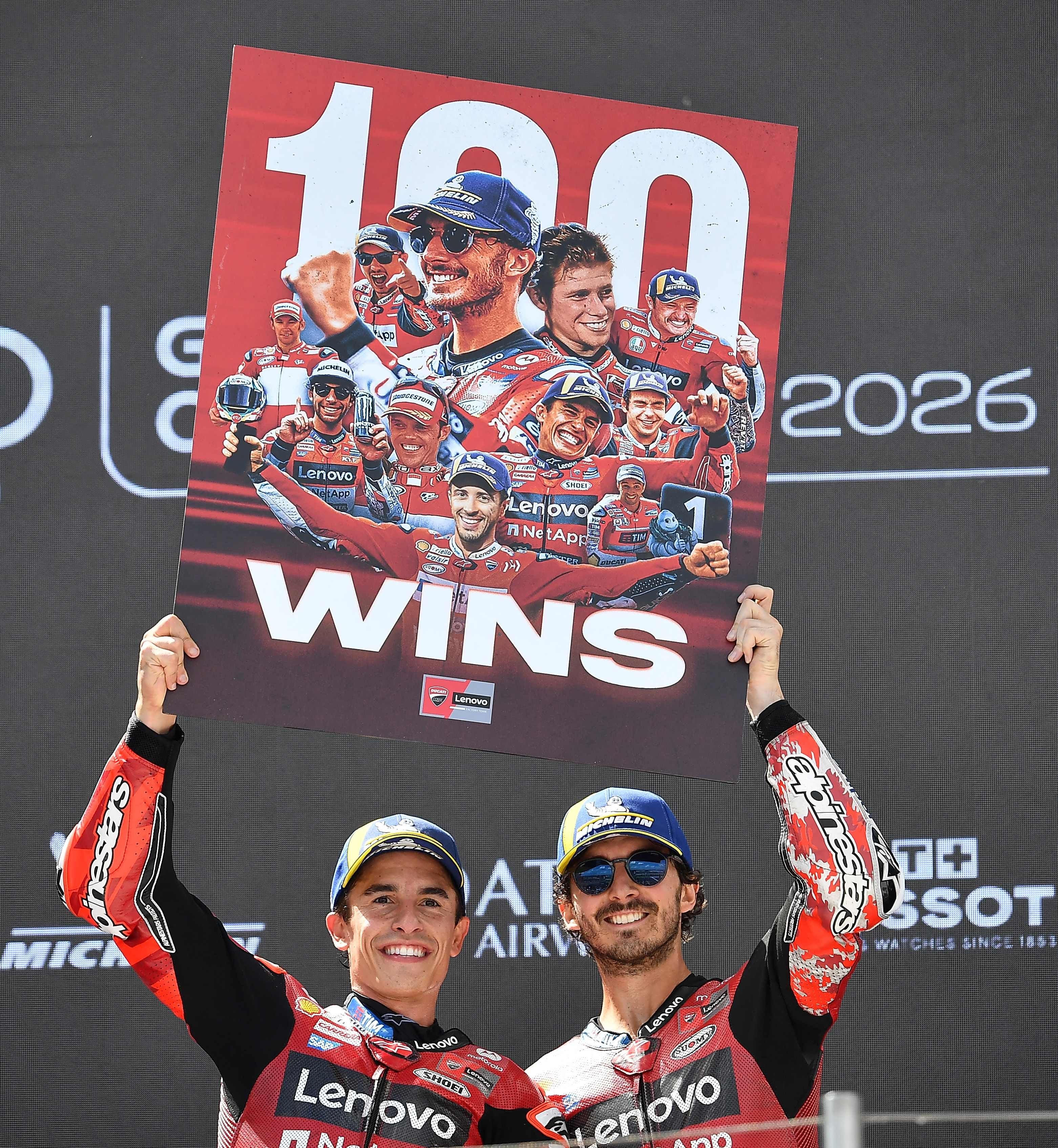 Winner Team Ducati Lenovo Team's Marc Marquez (L) and third placed Team Ducati Lenovo Team's Francesco Bagnaia celebrate with a sign to mark Marquez' 100-win mark on the podium of the Hungarian Motorcycle MotoGP Grand Prix at the Balaton Park circuit in Balatonfokajar, Hungary, on June 7, 2026. (Photo by Ferenc ISZA / AFP)