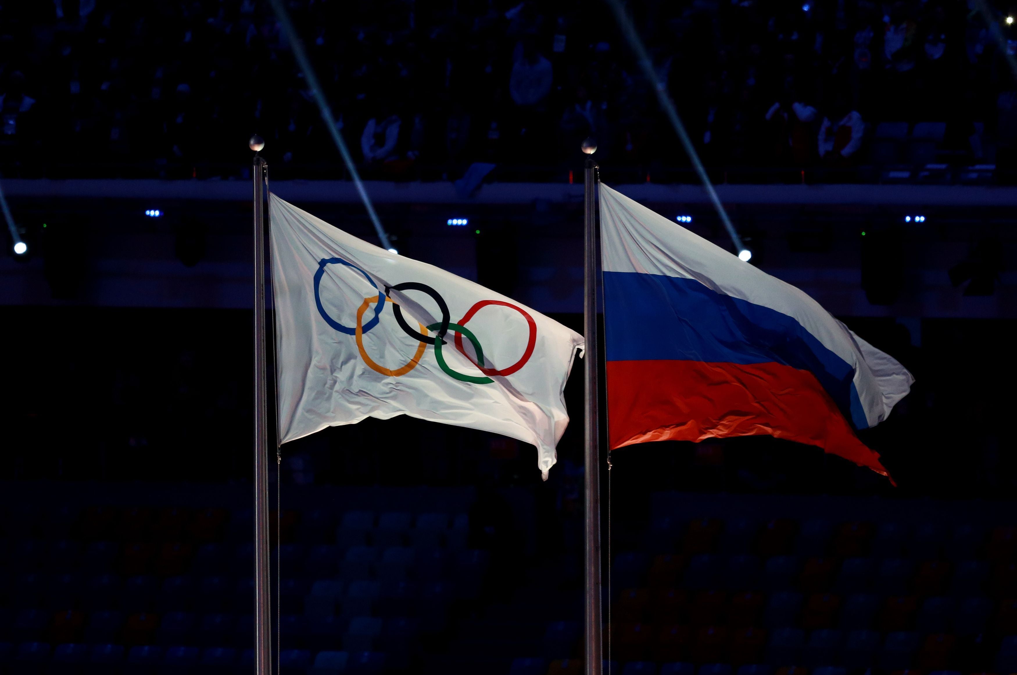 Die olympische Flagge weht neben der russischen Flagge bei einer Zeremonie im Stadion.