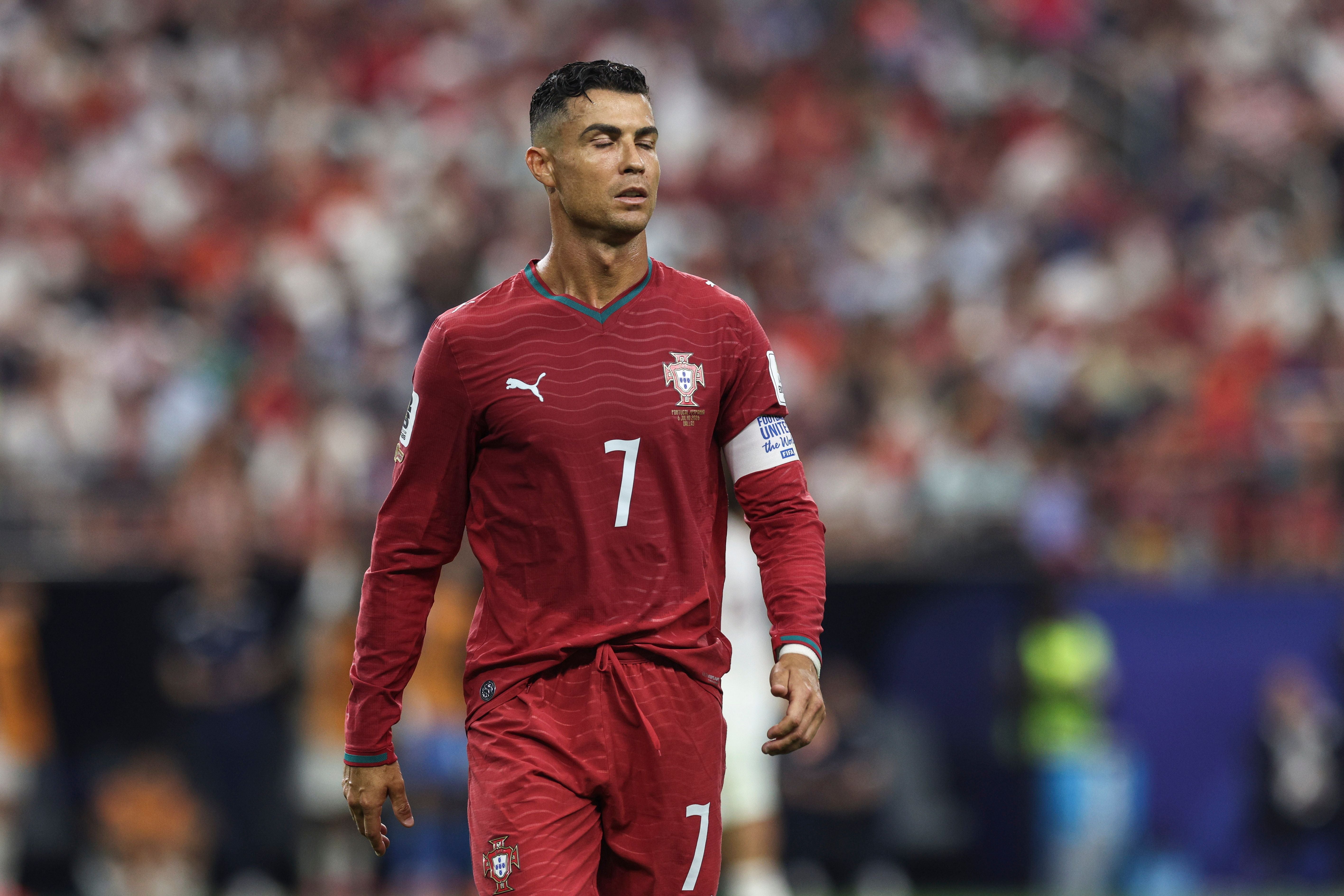 Ein portugiesischer Fußballspieler im roten Trikot wirkt enttäuscht auf dem Spielfeld.