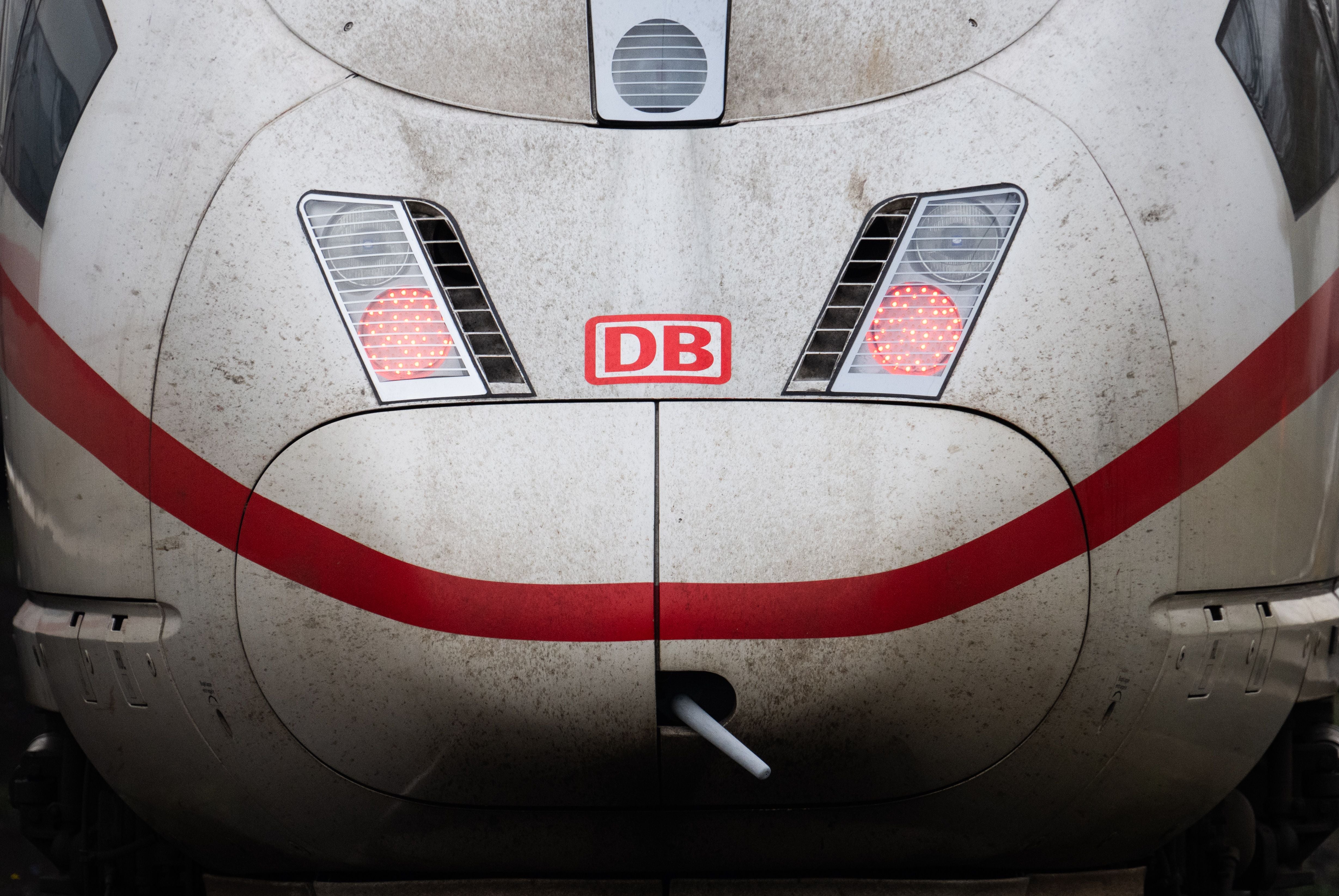 Front eines verschmutzten ICE-Zugs mit DB-Logo und leuchtenden Rücklichtern am Hauptbahnhof Frankfurt.