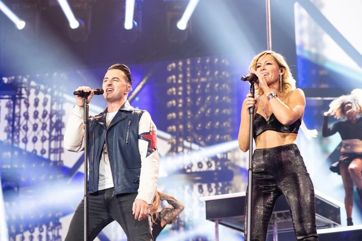 Helene Fischer und Andreas Gabalier singen gemeinsam auf einer hell beleuchteten Bühne.