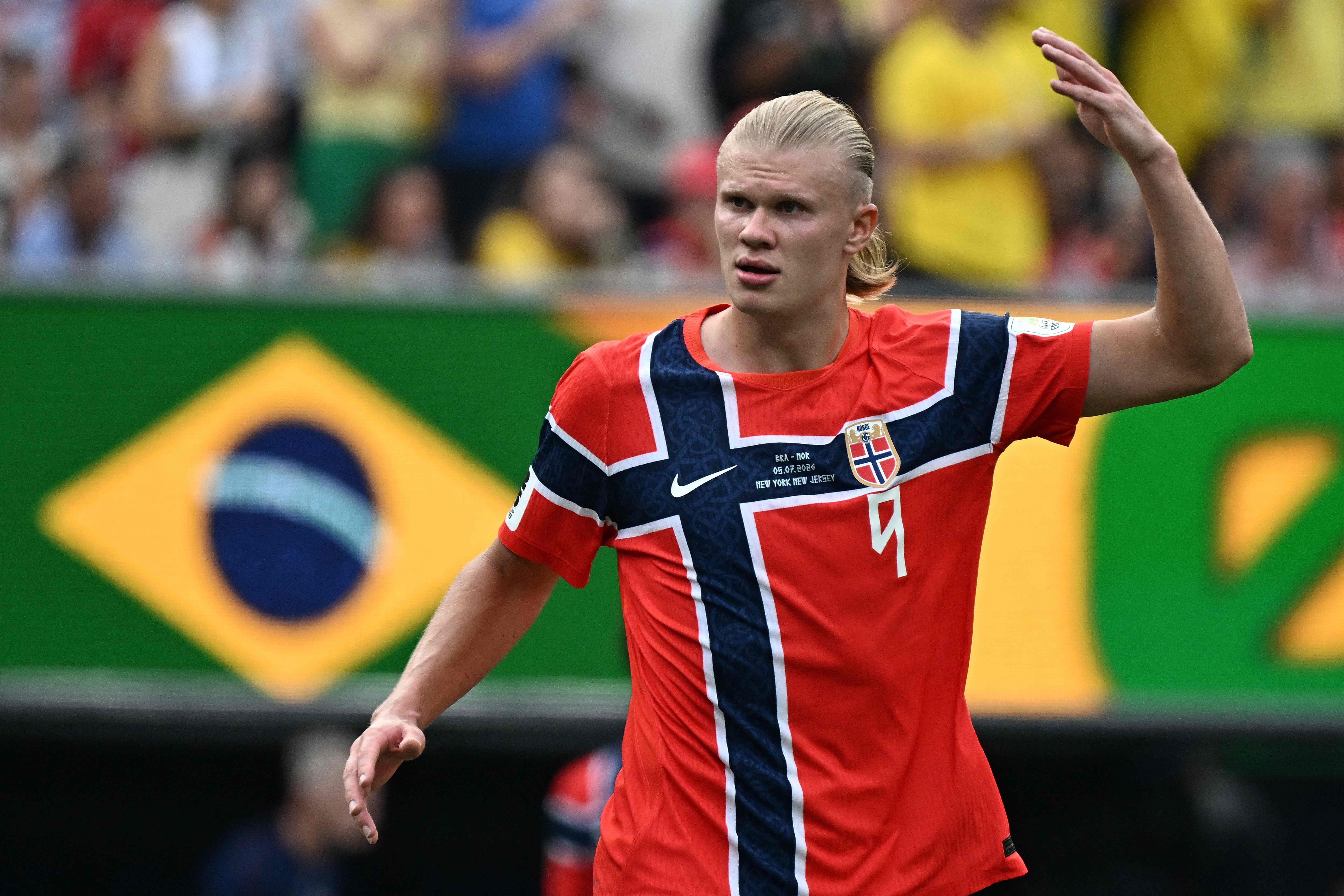 Ein norwegischer Fußballspieler im roten Trikot gestikuliert während eines Spiels im Stadion.