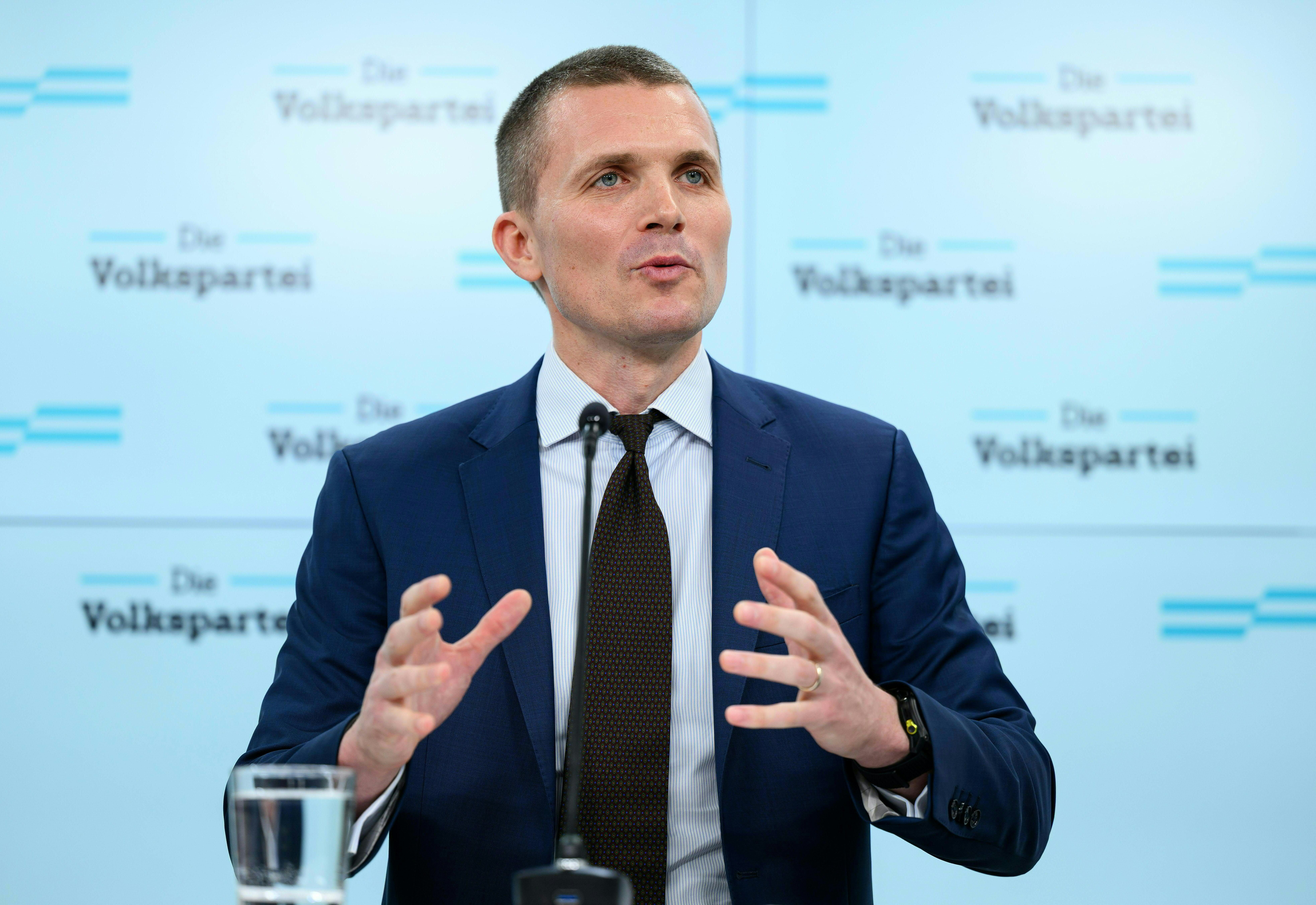 Ein Mann im Anzug spricht bei einer Pressekonferenz, im Hintergrund steht "Die Volkspartei".