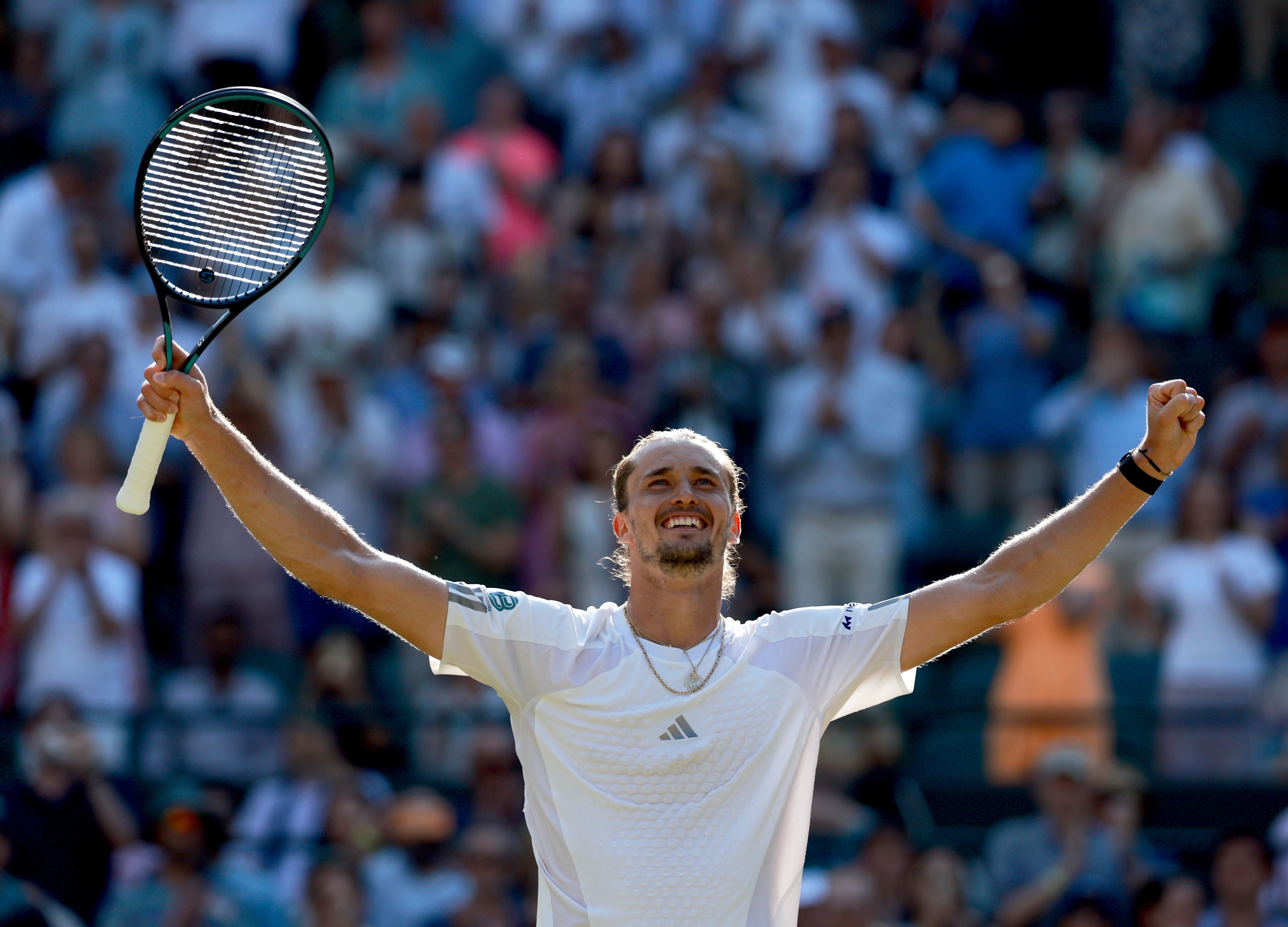 Tennis­spieler jubelt mit ausgebreiteten Armen und Schläger, Zuschauer im Hintergrund.
