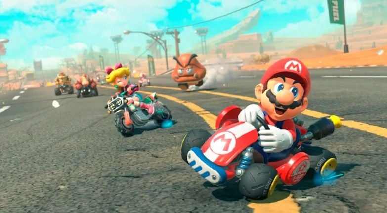Mario und andere Charaktere fahren in Karts auf einer Rennstrecke bei Mario Kart.