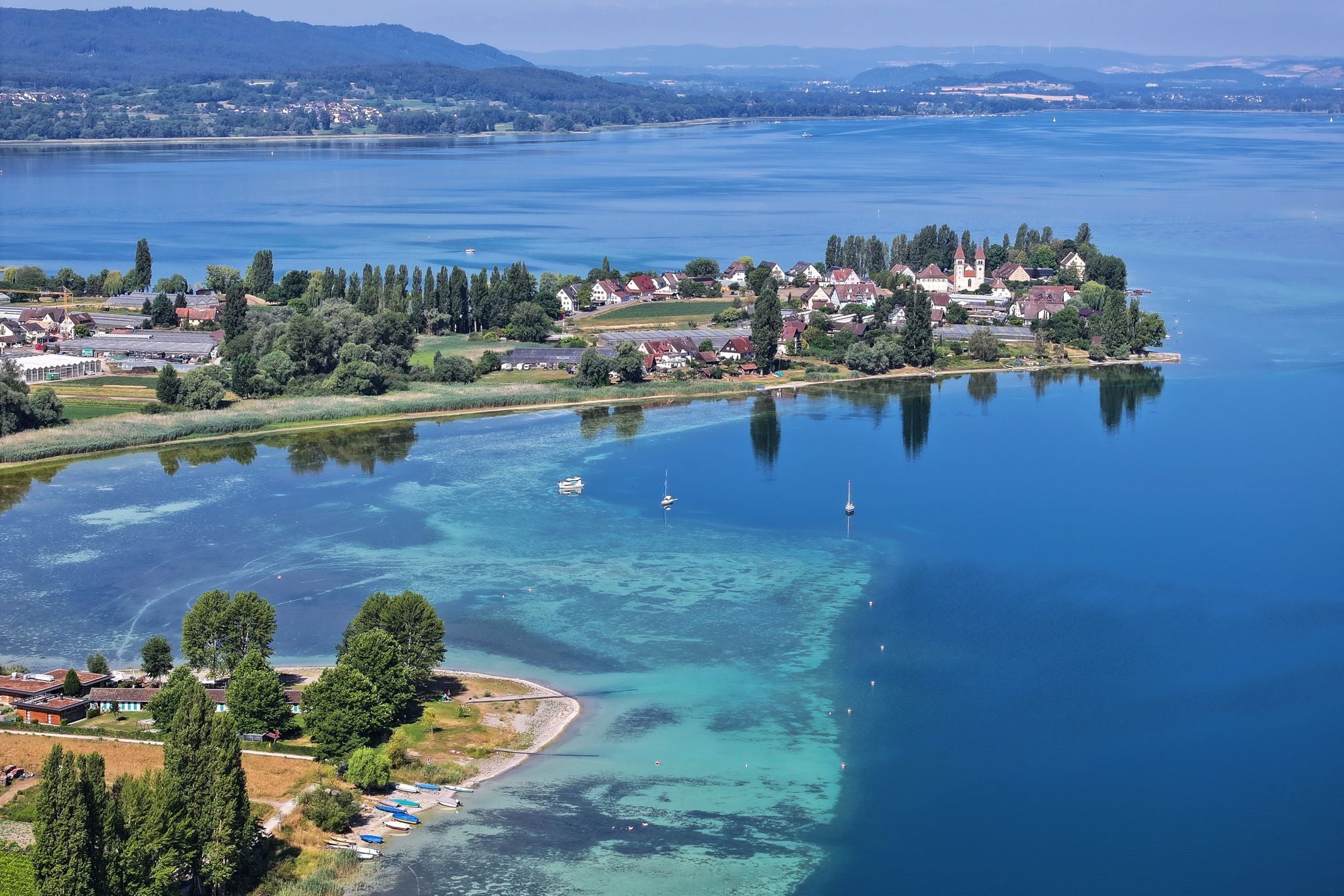 Blick auf die Insel Reichenau im Bodensee bei Niedrigwasser, Ufergrund und Boote sind deutlich sichtbar.