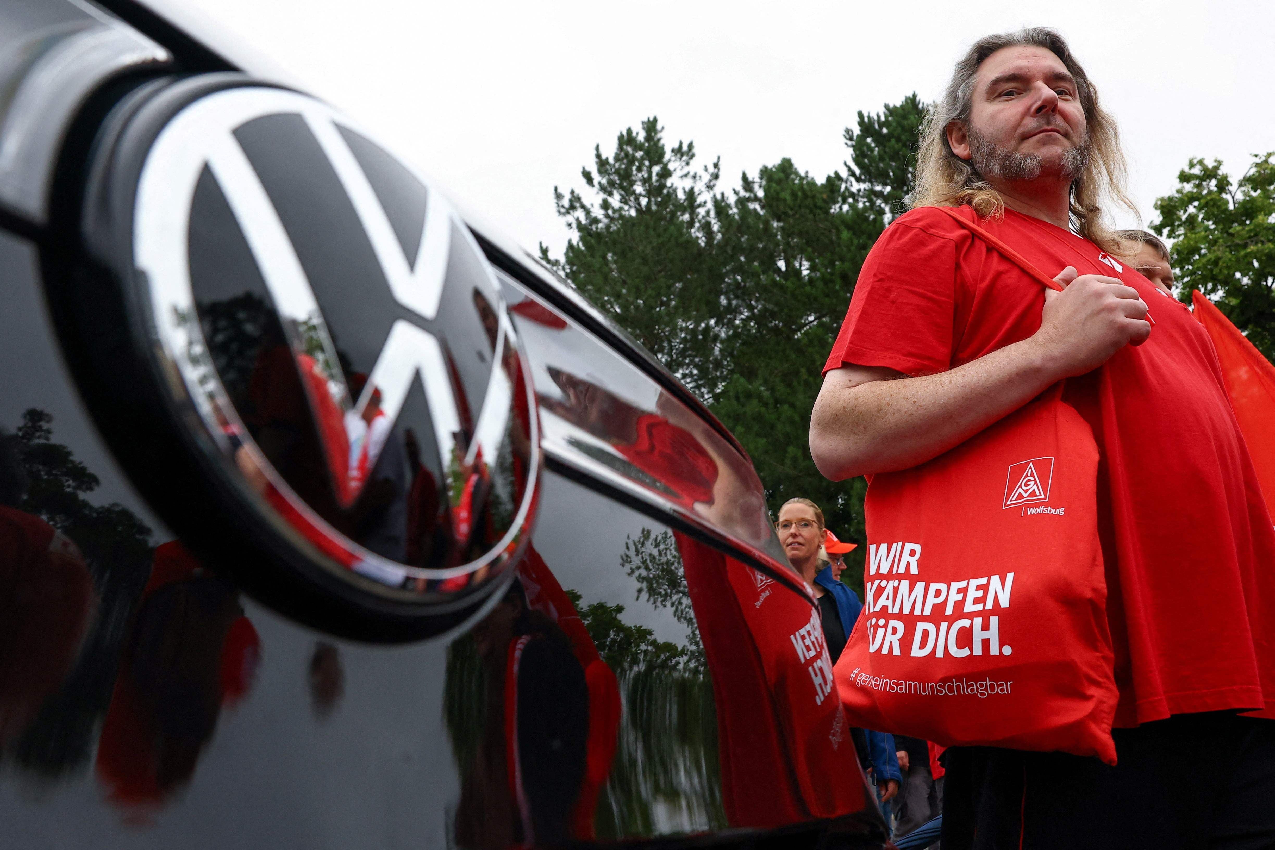 Ein VW-Mitarbeiter mit IG Metall-Tasche protestiert am Werk Wolfsburg gegen geplanten Stellenabbau.