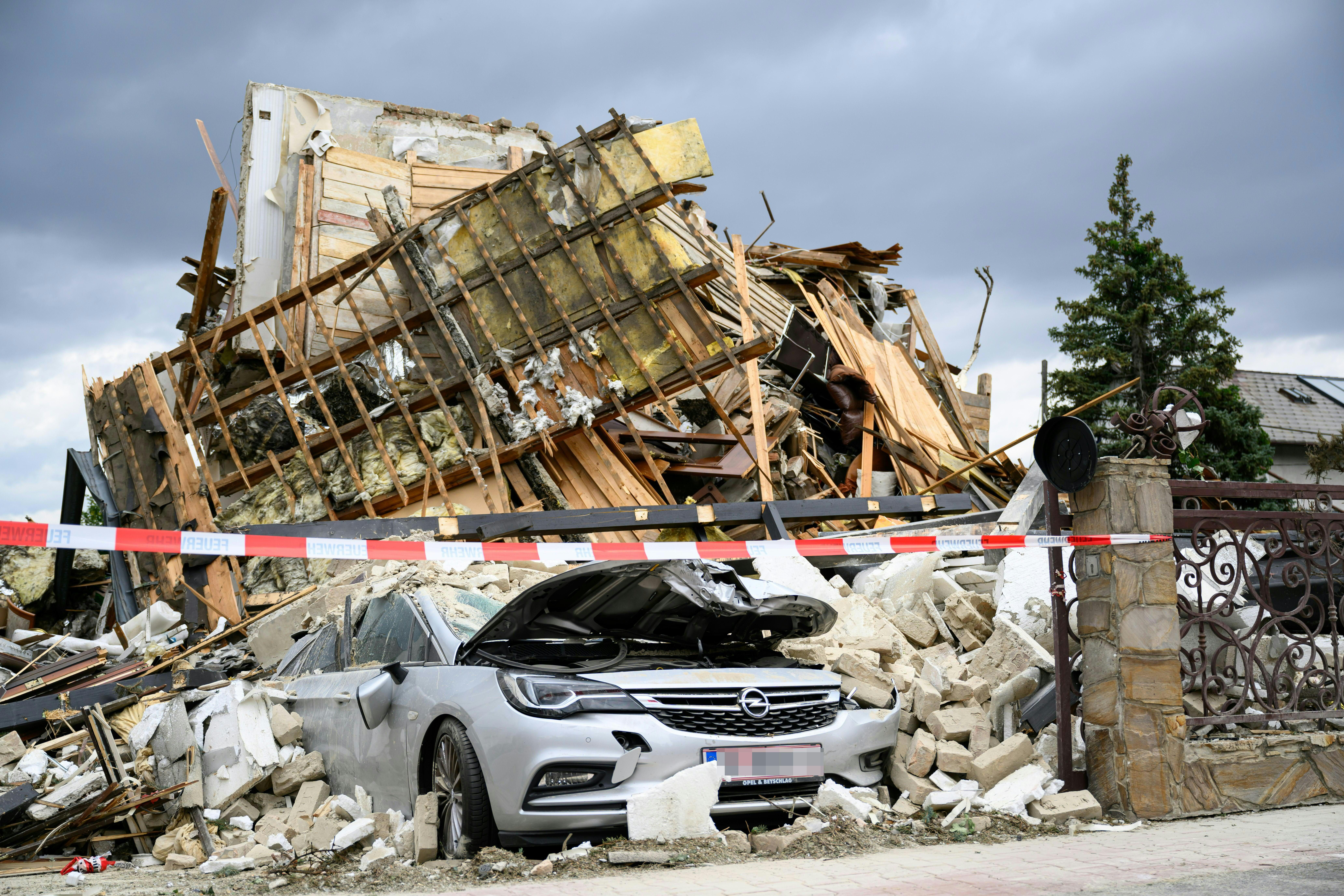 Ein Auto ist unter Trümmern eines eingestürzten Hauses nach einer Explosion begraben.