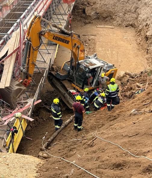 Mehrere Feuerwehrleute retten bei einem umgestürzten Bagger auf einer Baustelle in Völkermarkt.