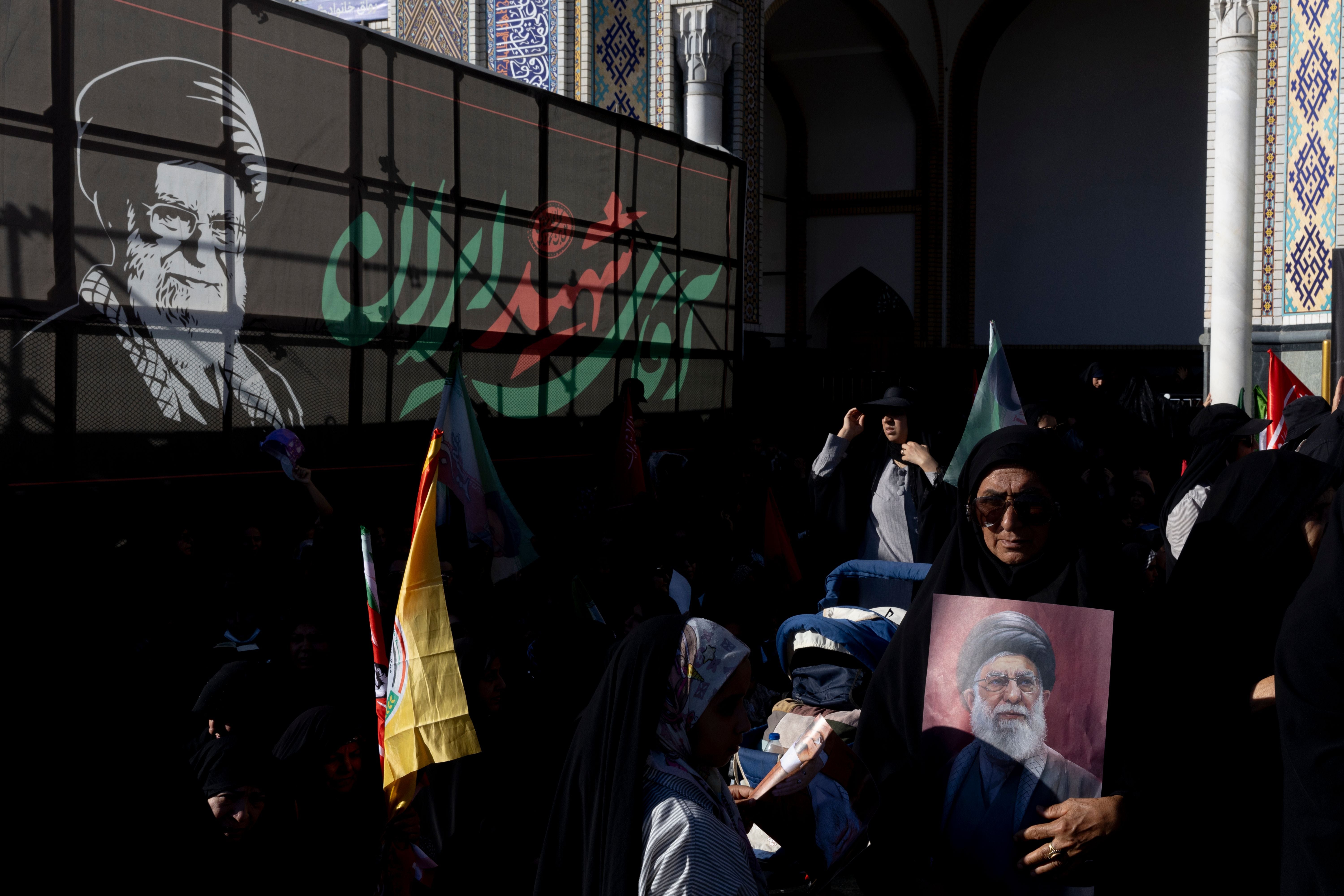 Eine Frau trägt das Porträt von Ayatollah Khamenei bei einer Trauerzeremonie in Mashhad, Iran.