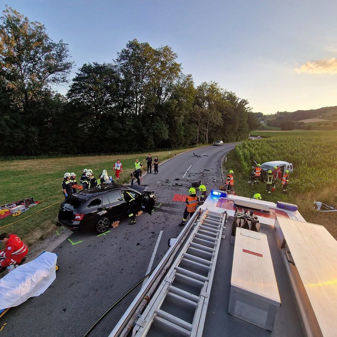 Feuerwehr und Rettungskräfte arbeiten an einem Unfallort mit zwei beschädigten Autos.