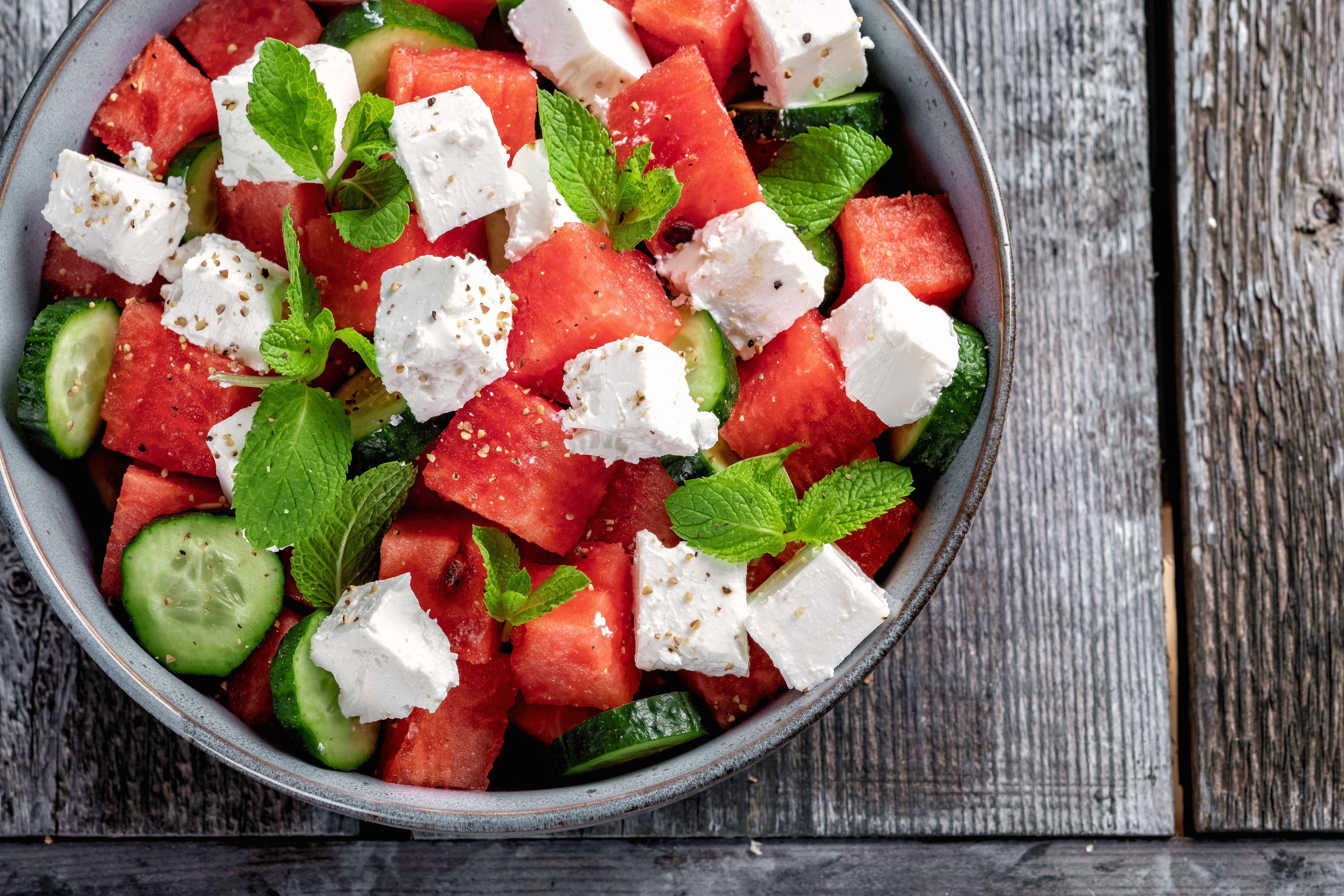 Sommerlicher Salat mit Wassermelone, Gurke, Feta und frischer Minze in einer Schüssel.