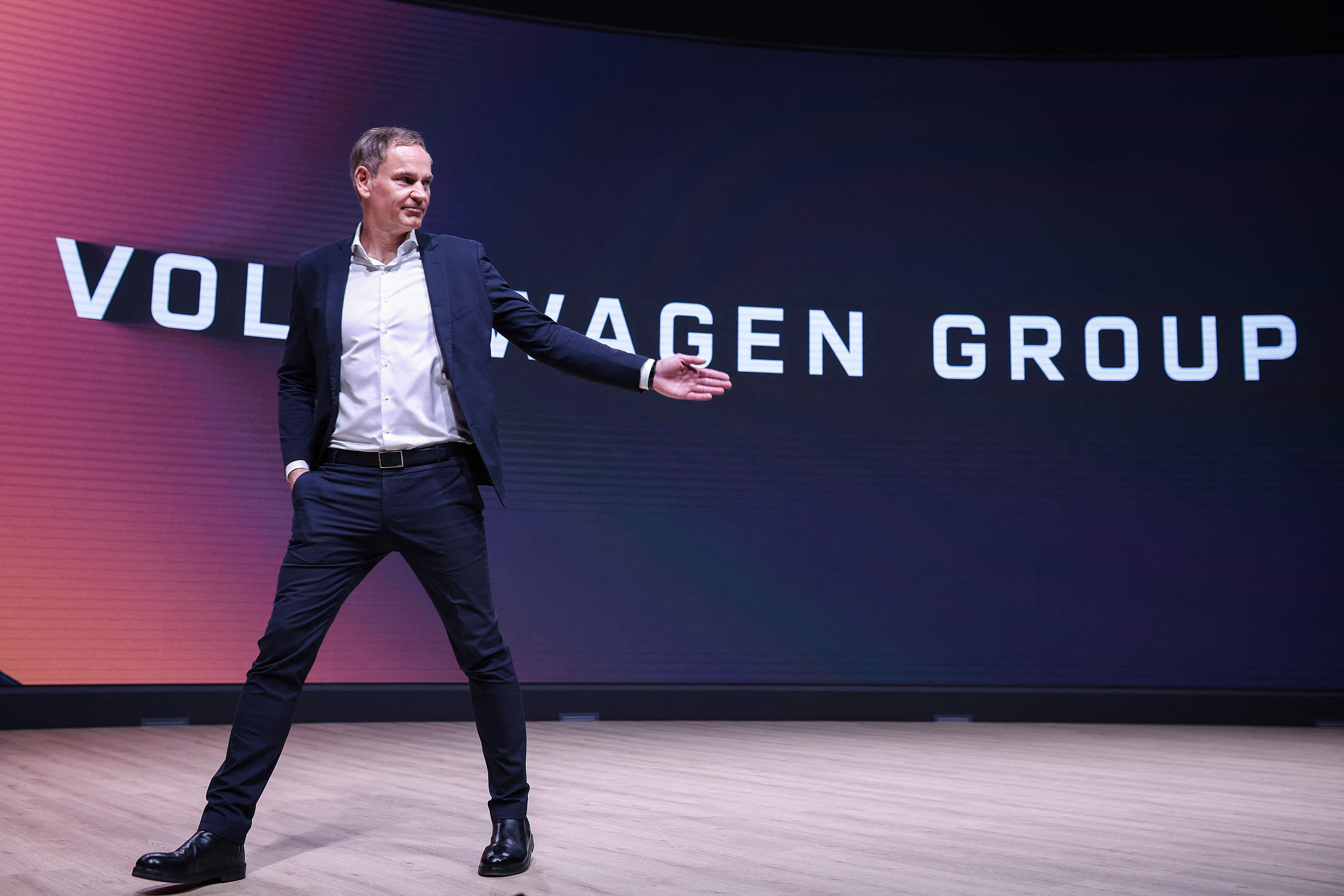 Ein Mann im Anzug steht auf einer Bühne vor der Aufschrift "VOLKSWAGEN GROUP".