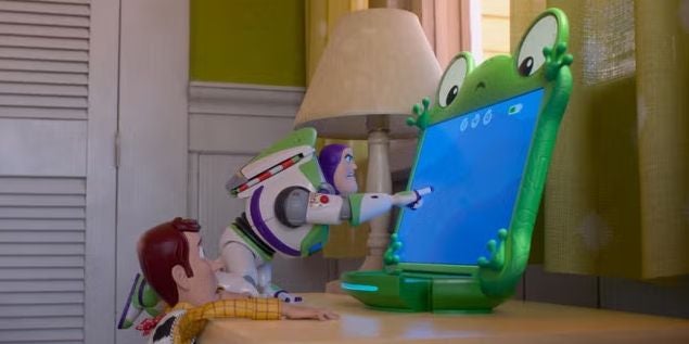 Buzz Lightyear und Woody schauen auf ein digital grünes Frosch-Tablet im Kinderzimmer.