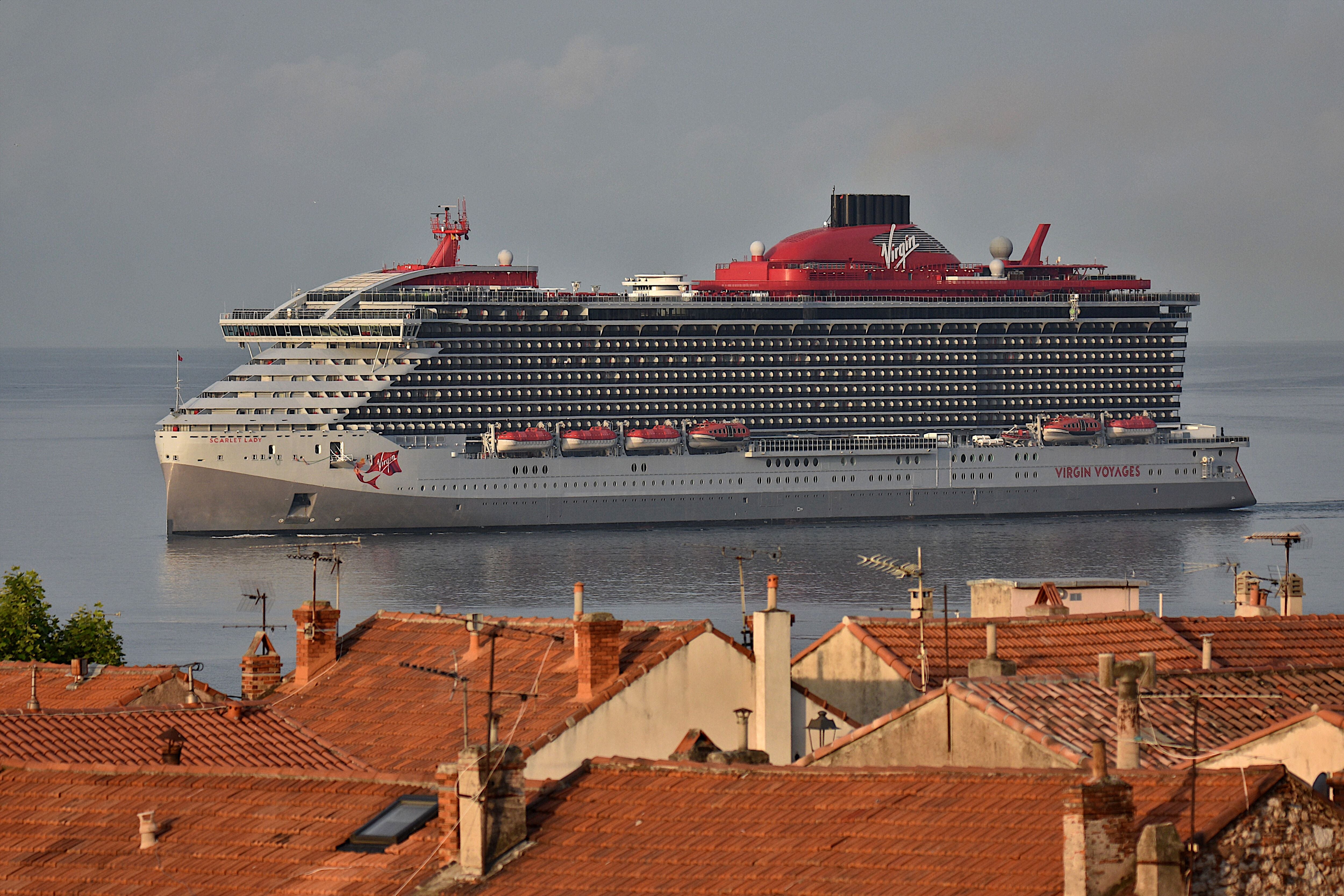 Das Kreuzfahrtschiff Scarlet Lady fährt am Hafen von Marseille vorbei, im Vordergrund sind Hausdächer.