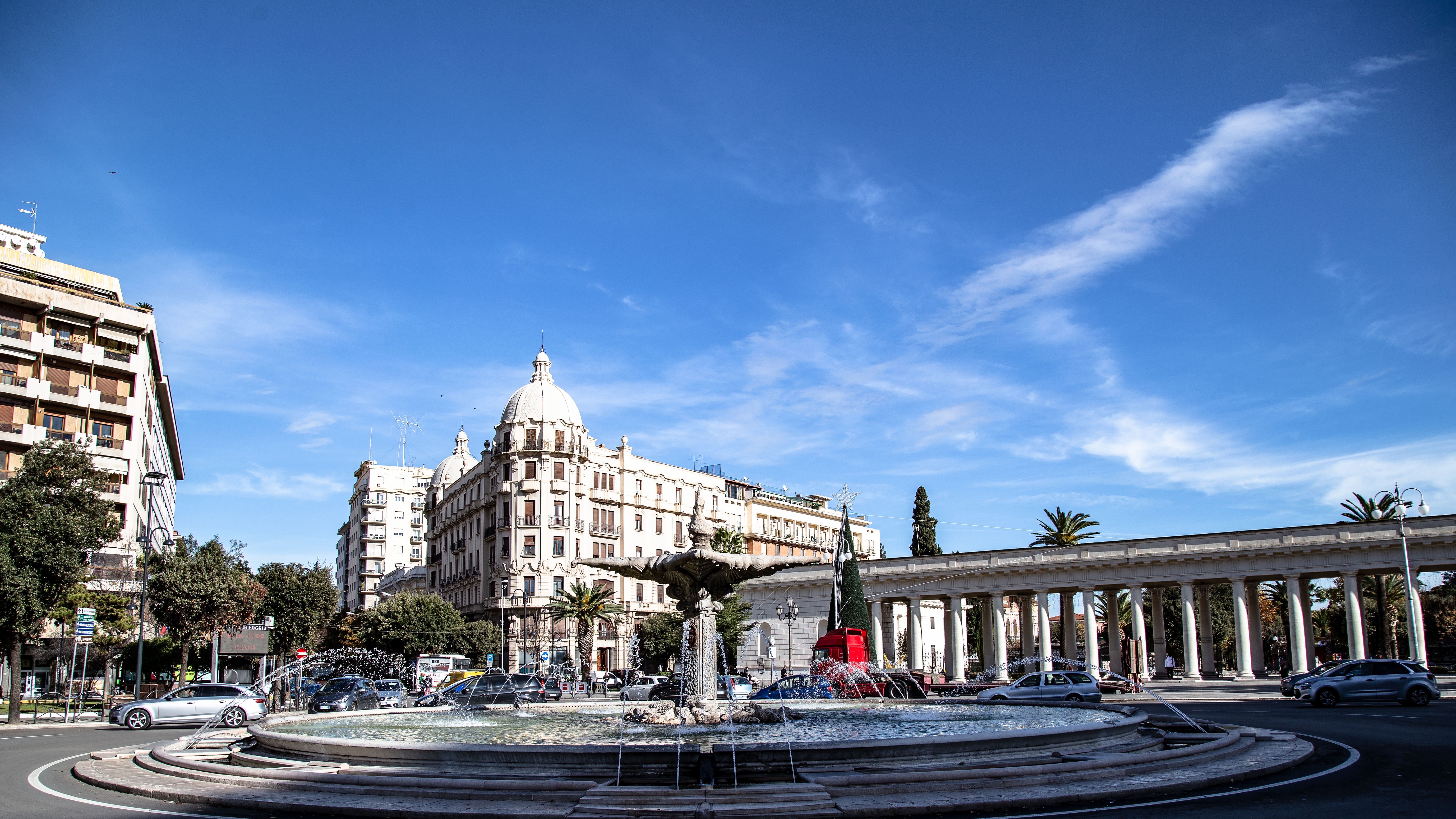 Springbrunnen Fontana del Sele in einem Kreisverkehr mit klassizistischen Gebäuden und blauem Himmel.