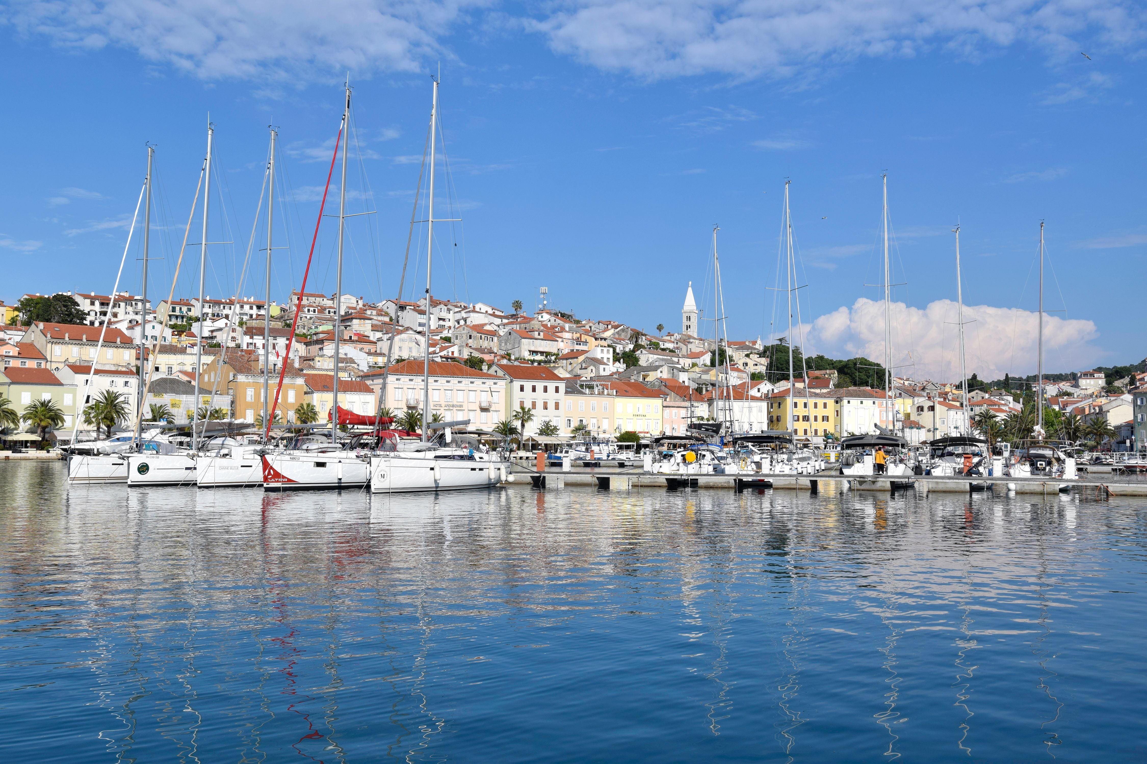 Segelboote liegen im Hafen vor den bunten Häusern von Mali Lošinj auf der Insel Lošinj.