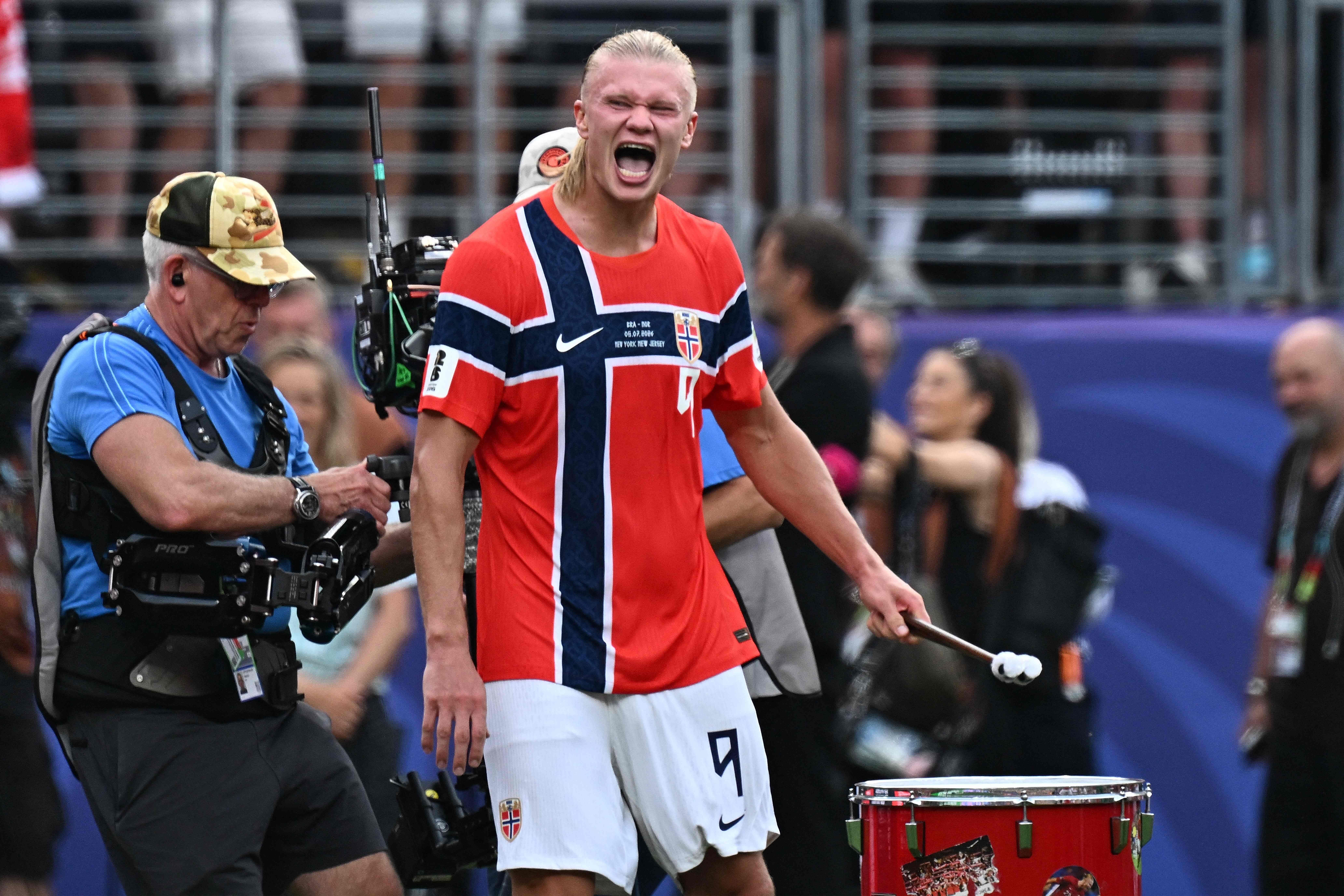 Ein norwegischer Fußballspieler schlägt jubelnd auf eine Trommel nach einem Spiel.