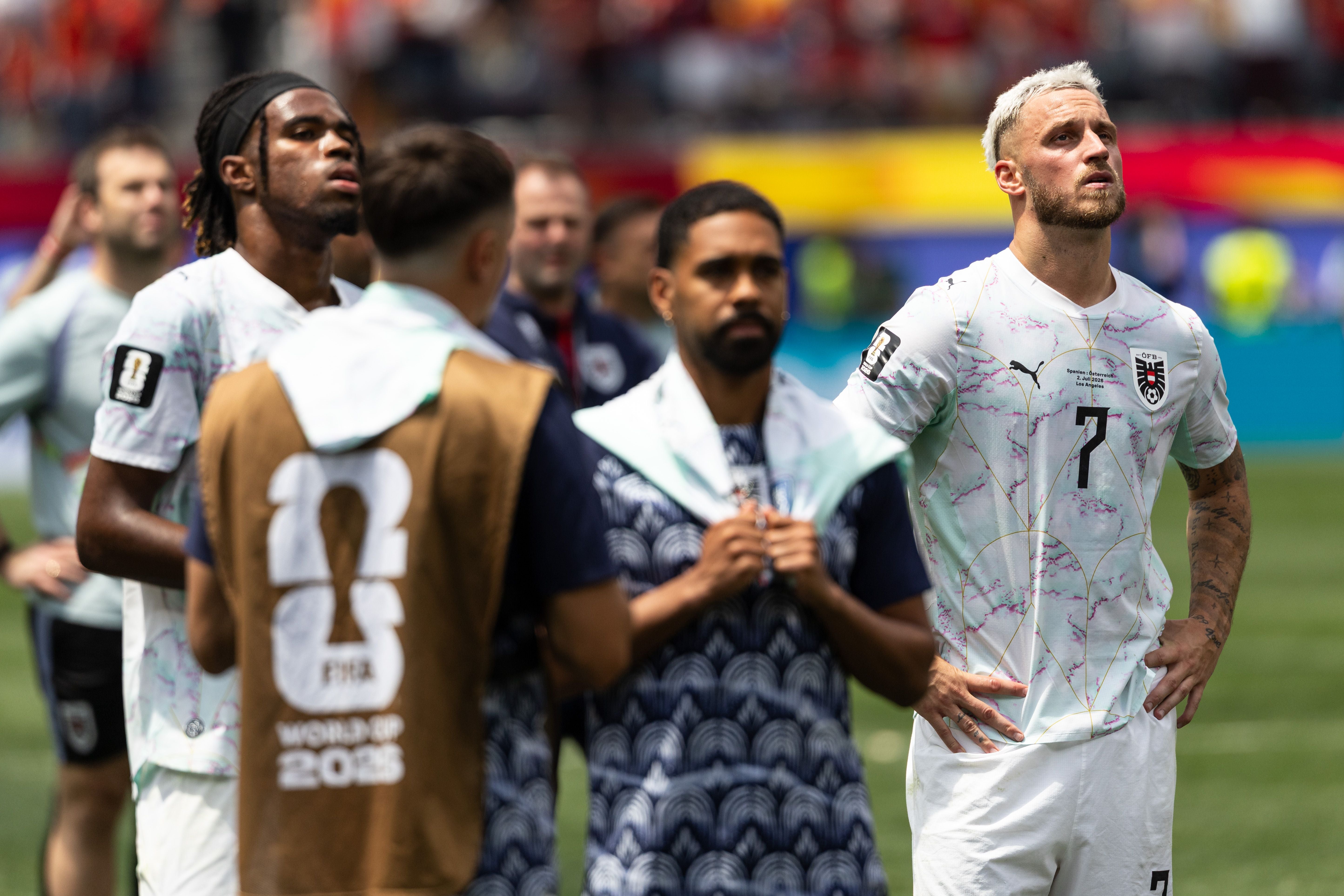 Österreichische Fußballspieler stehen enttäuscht nach dem WM-Spiel auf dem Spielfeld.