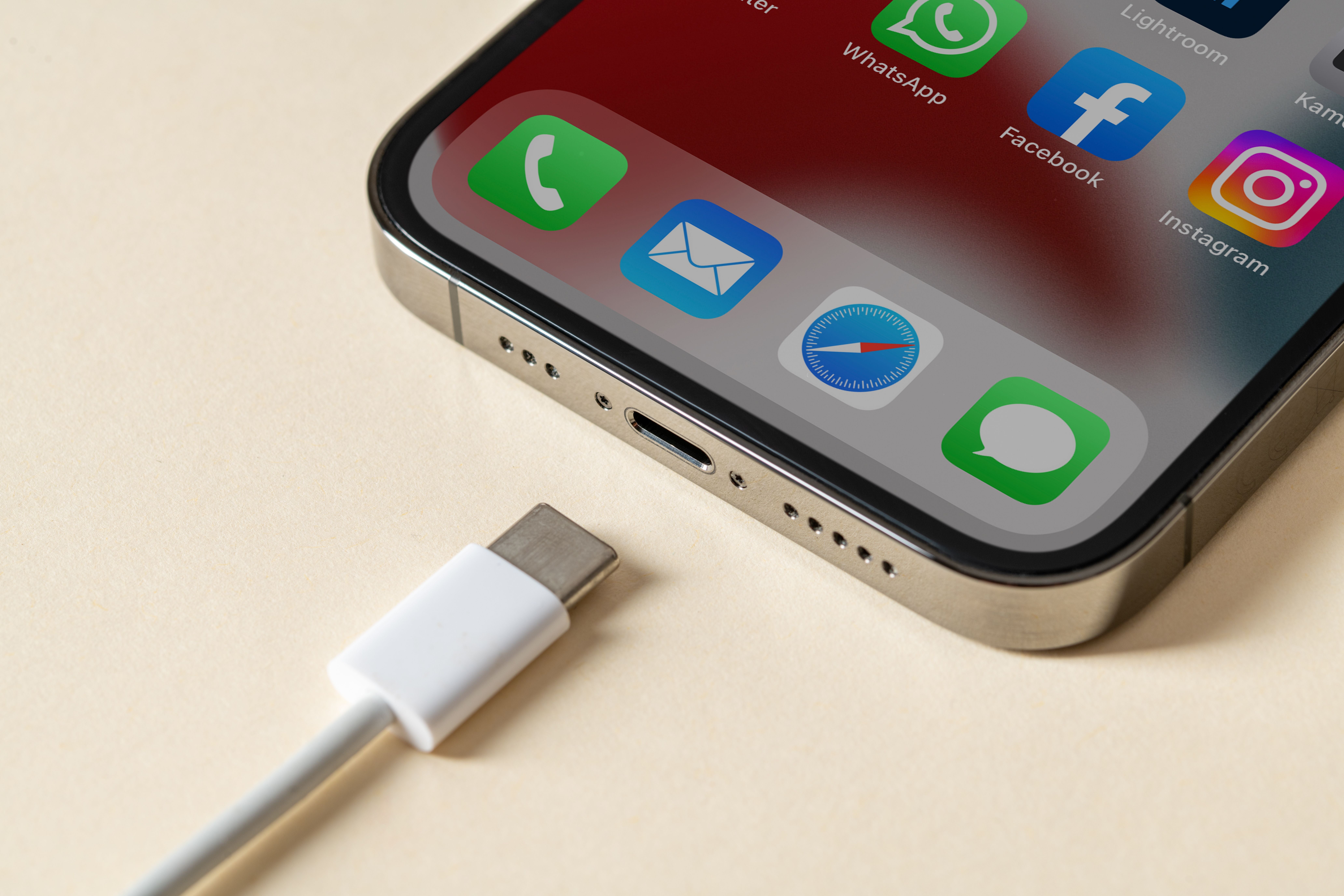 Nahaufnahme eines iPhone 13 Pro mit USB-C-Ladekabel vor dem Ladeanschluss.