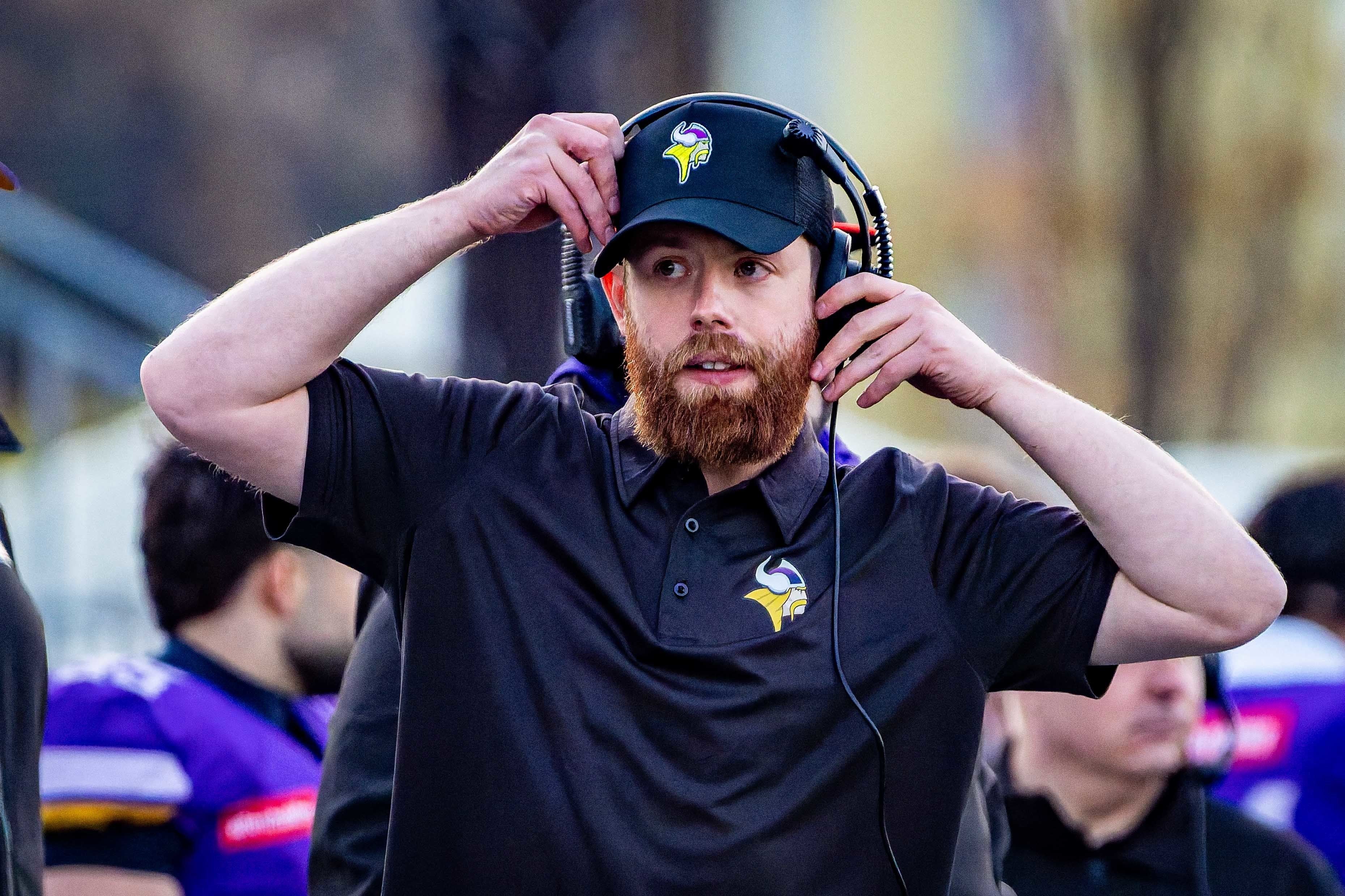 Ein Football-Trainer der Vienna Vikings mit Headset und Kappe an der Seitenlinie.