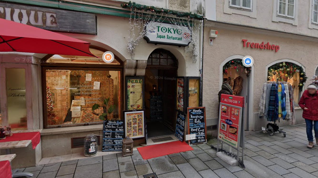 Eingang eines japanischen Restaurants mit Werbetafeln und Menüs vor der Tür.