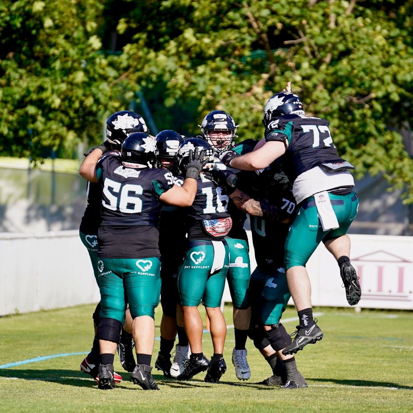 American-Football-Spieler der Dragons feiern gemeinsam auf dem Spielfeld.