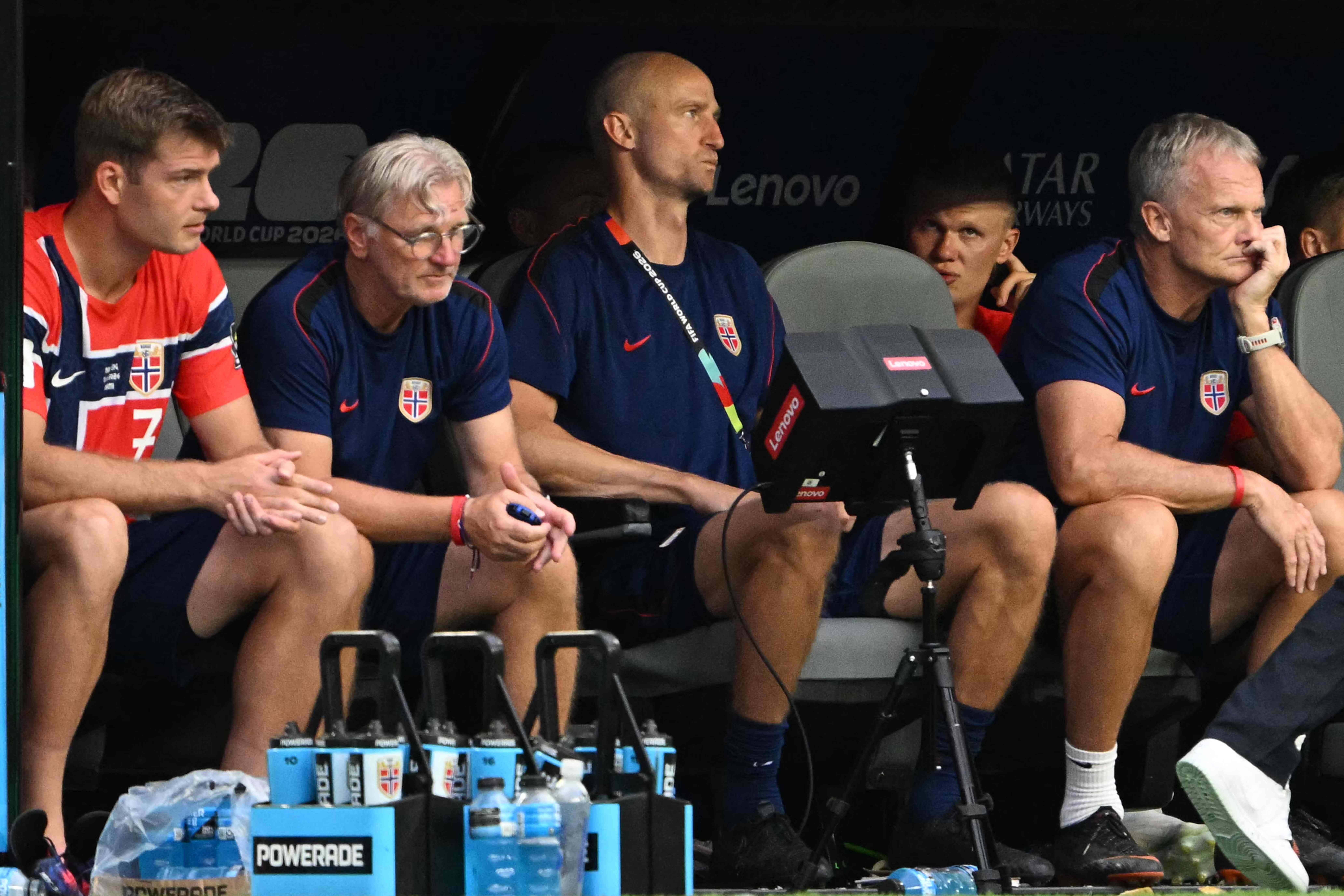 Norwegische Fußballspieler und Trainer sitzen nach einer Auswechslung nachdenklich auf der Bank.