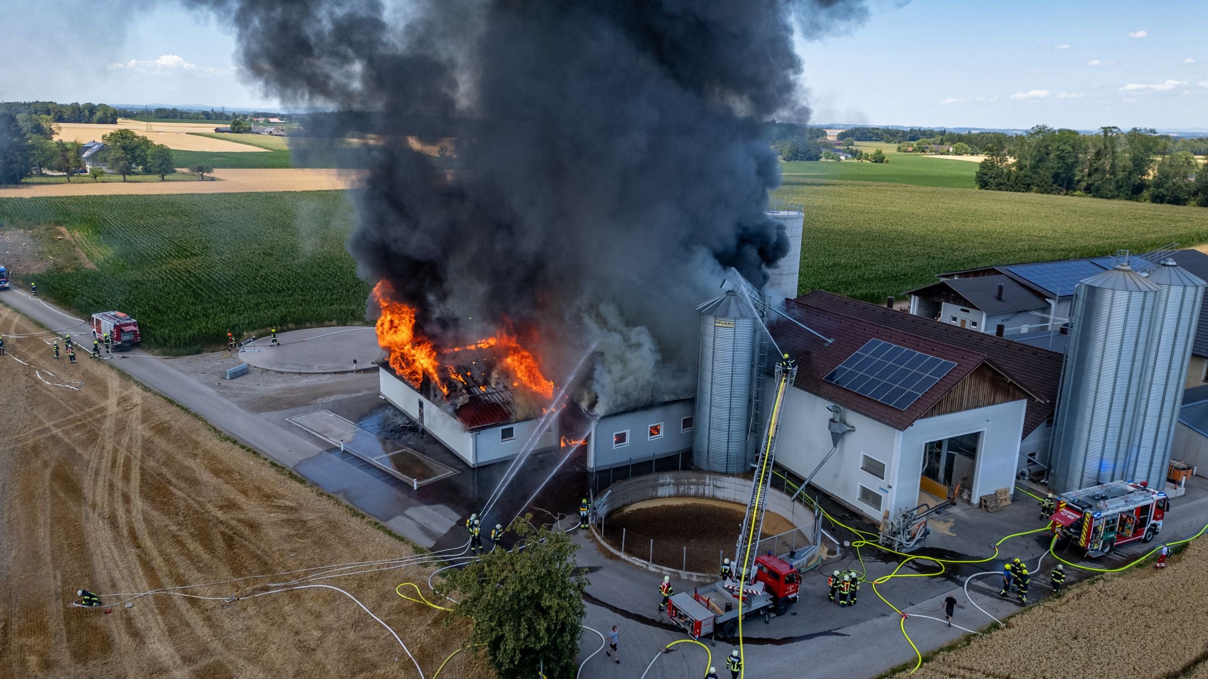 Großbrand auf einem landwirtschaftlichen Betrieb, Feuerwehr löscht das brennende Gebäude.