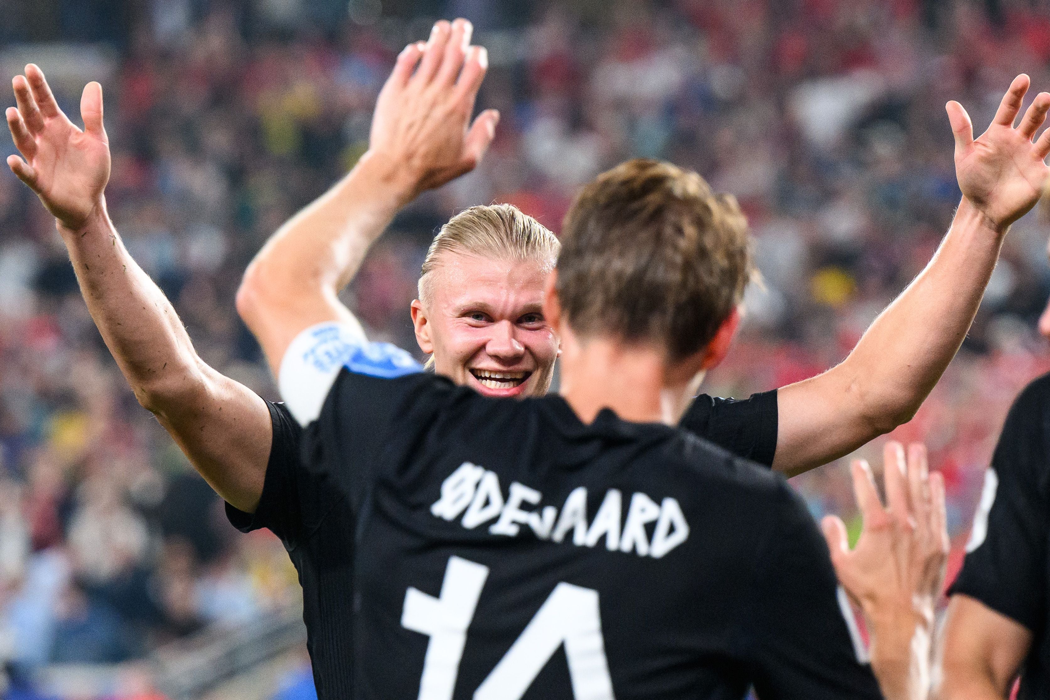 Erling Haaland und Martin Odegaard jubeln gemeinsam im Fußballstadion.