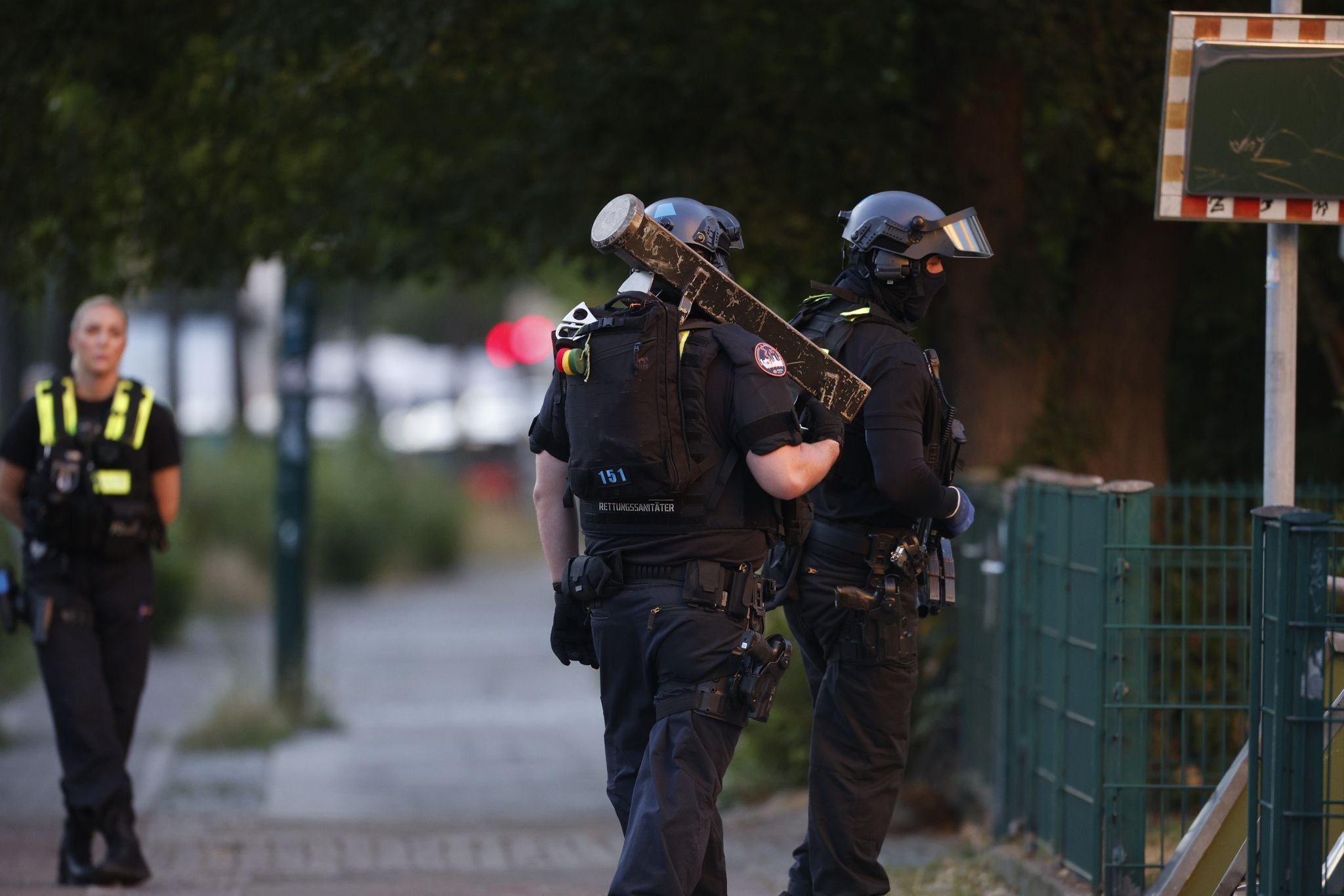 Berlin: Eine Einsatzkraft der Polizei ist in der Nähe einer Geiselnahme in einem Supermarkt im Einsatz und trägt eine Ramme.