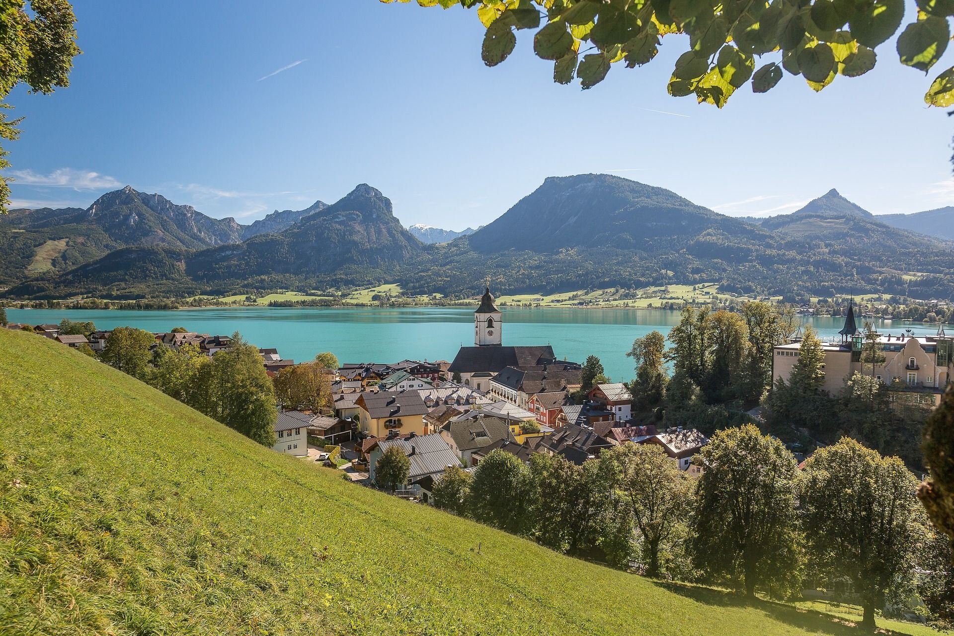 Blick auf den Wolfgangsee mit niedrigem Wasserstand, umgeben von Bergen und einer kleinen Stadt.