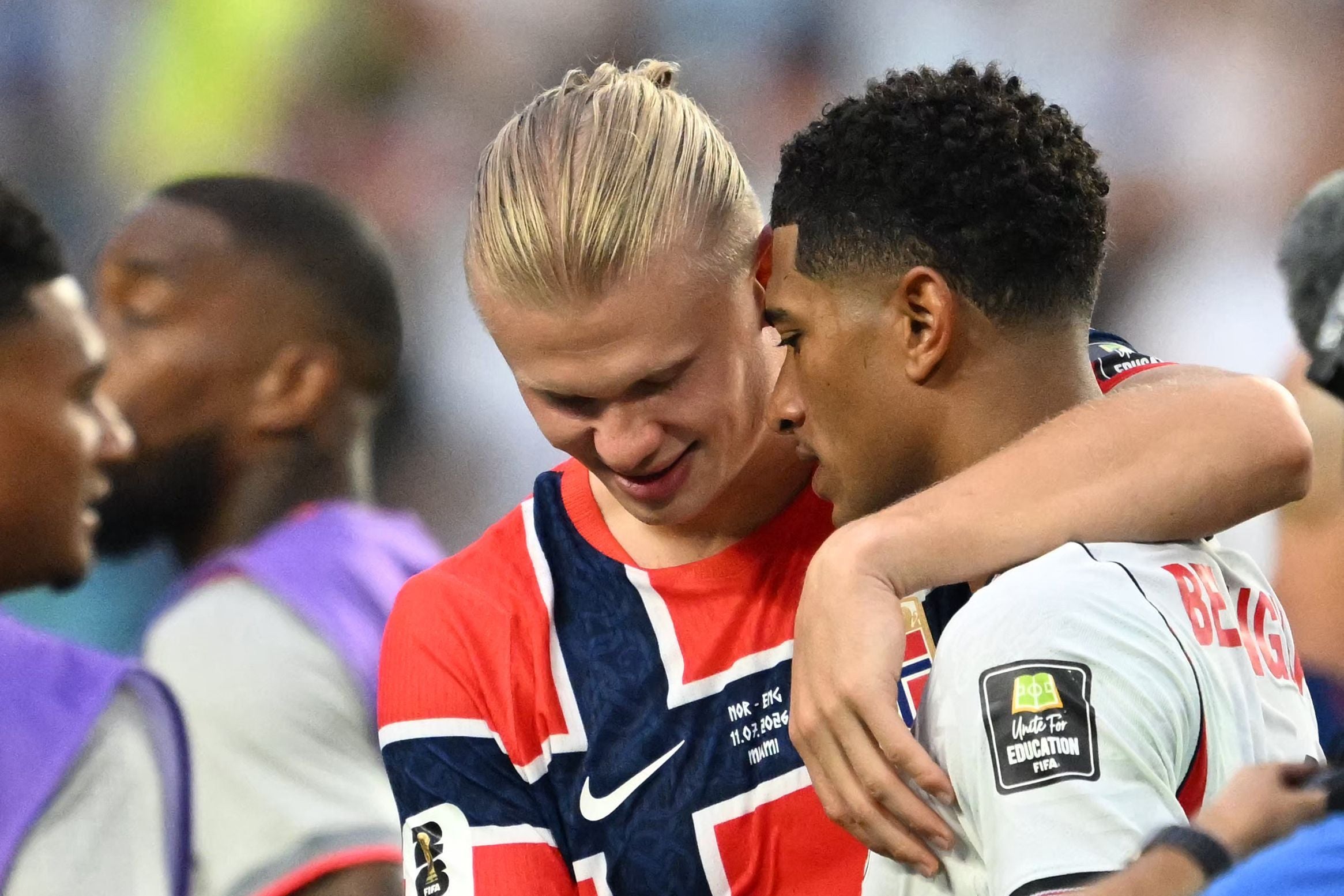 Zwei Fußballspieler umarmen sich nach einem Spiel im Stadion freundschaftlich.