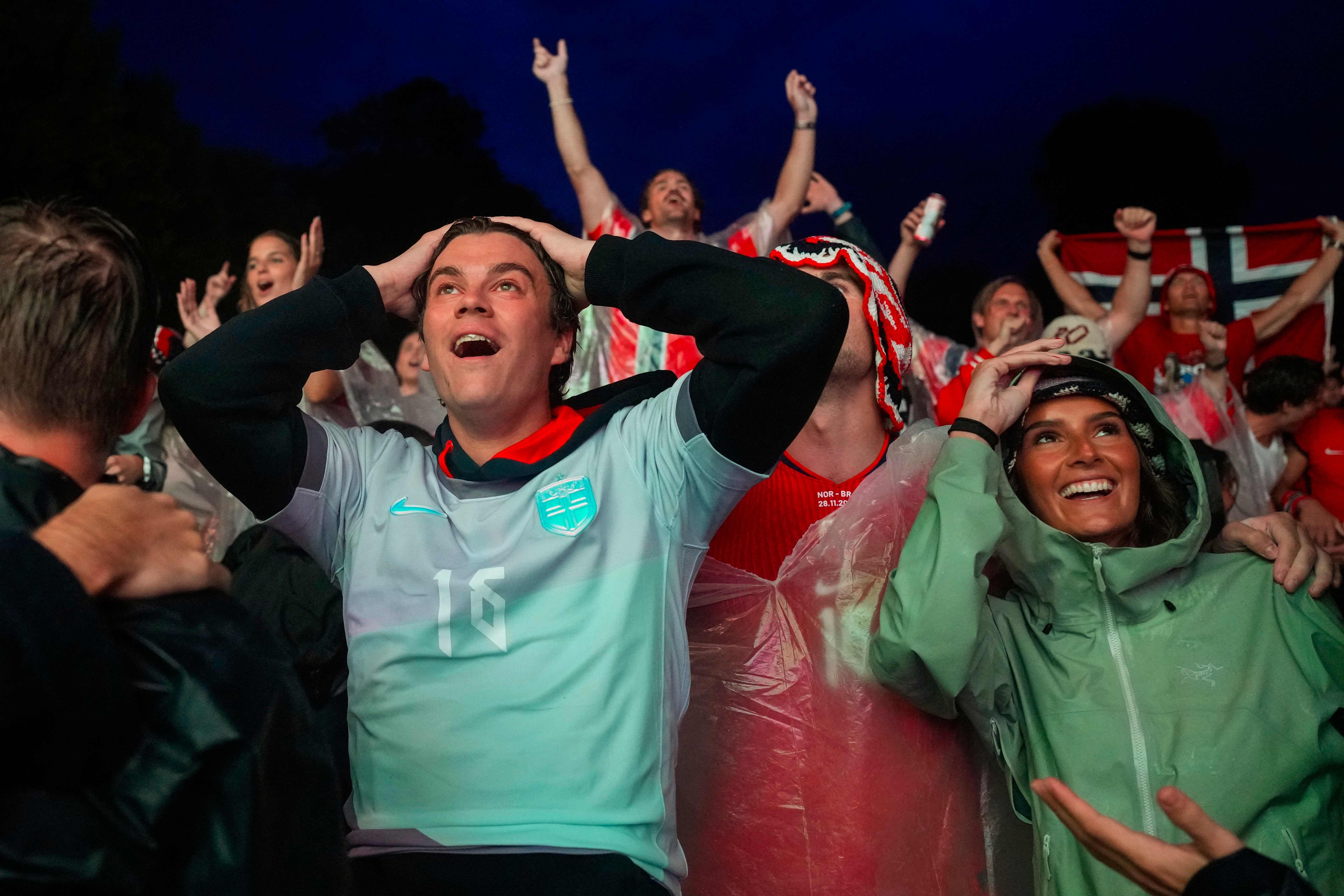 Fußballfans jubeln und zeigen starke Emotionen beim Public Viewing in Oslo bei Nacht.
