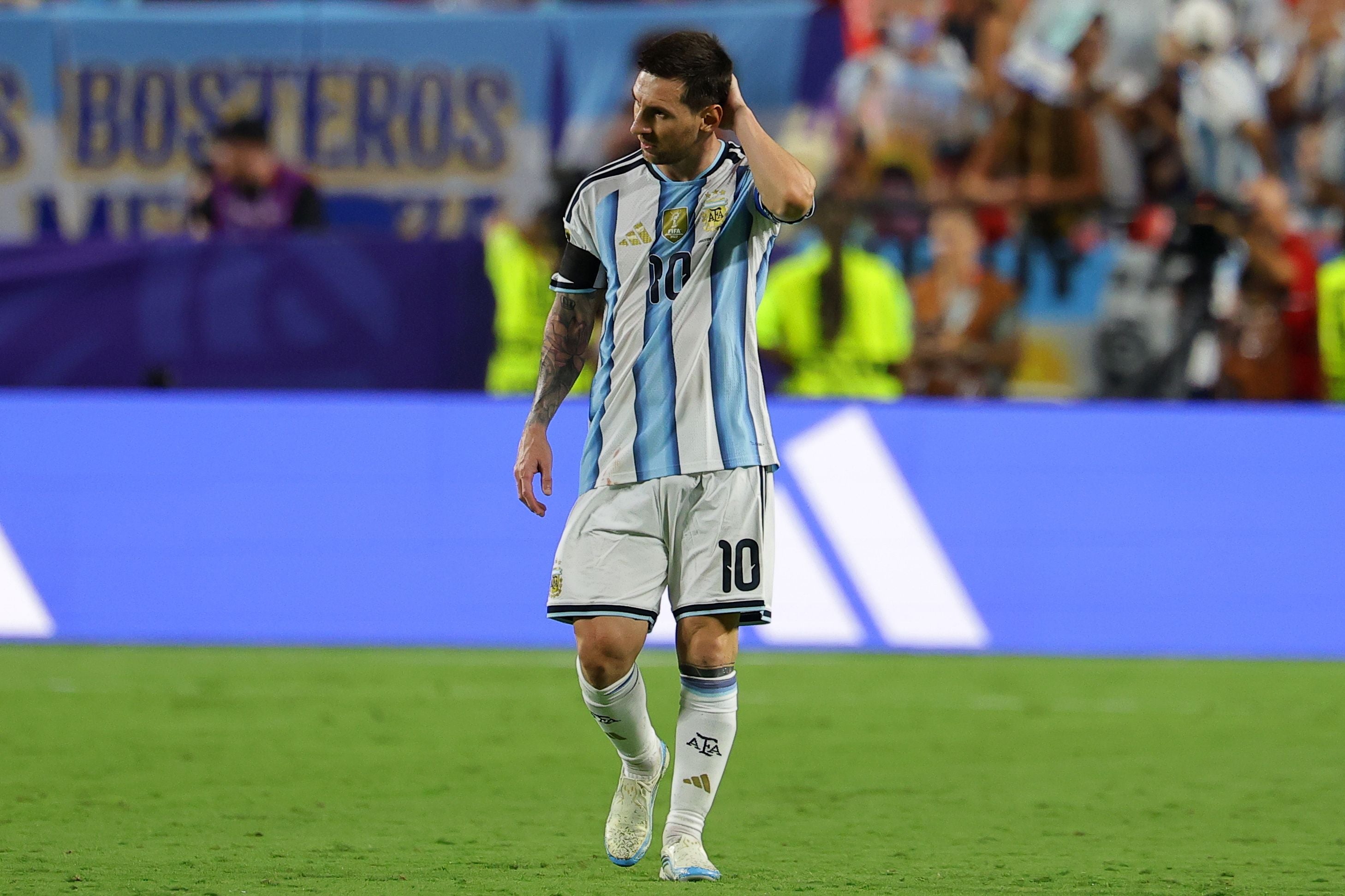 Ein argentinischer Fußballspieler im Trikot läuft nachdenklich über das Spielfeld.