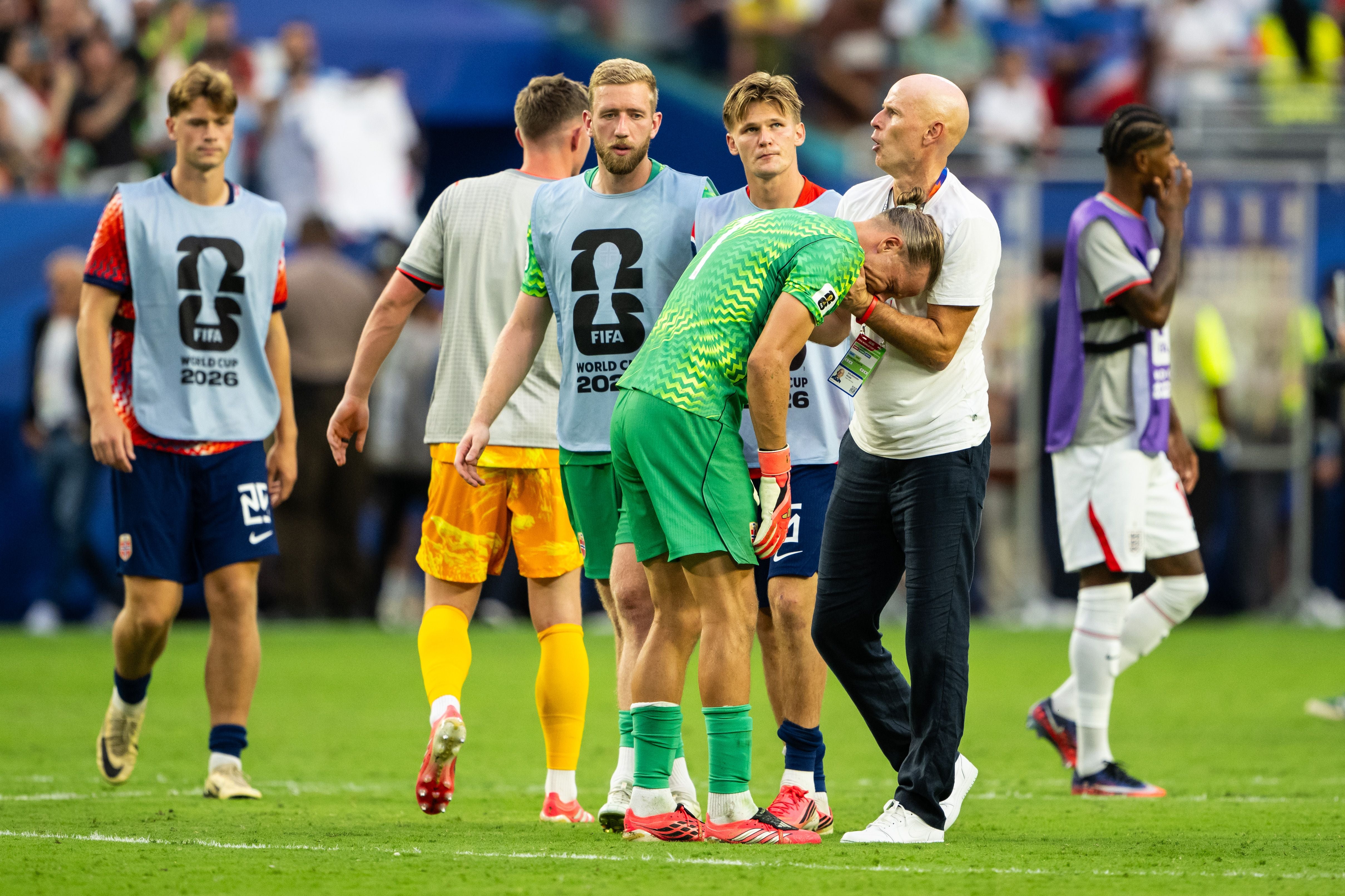 Trainer tröstet einen niedergeschlagenen norwegischen Torwart nach einem WM-Spiel auf dem Spielfeld.
