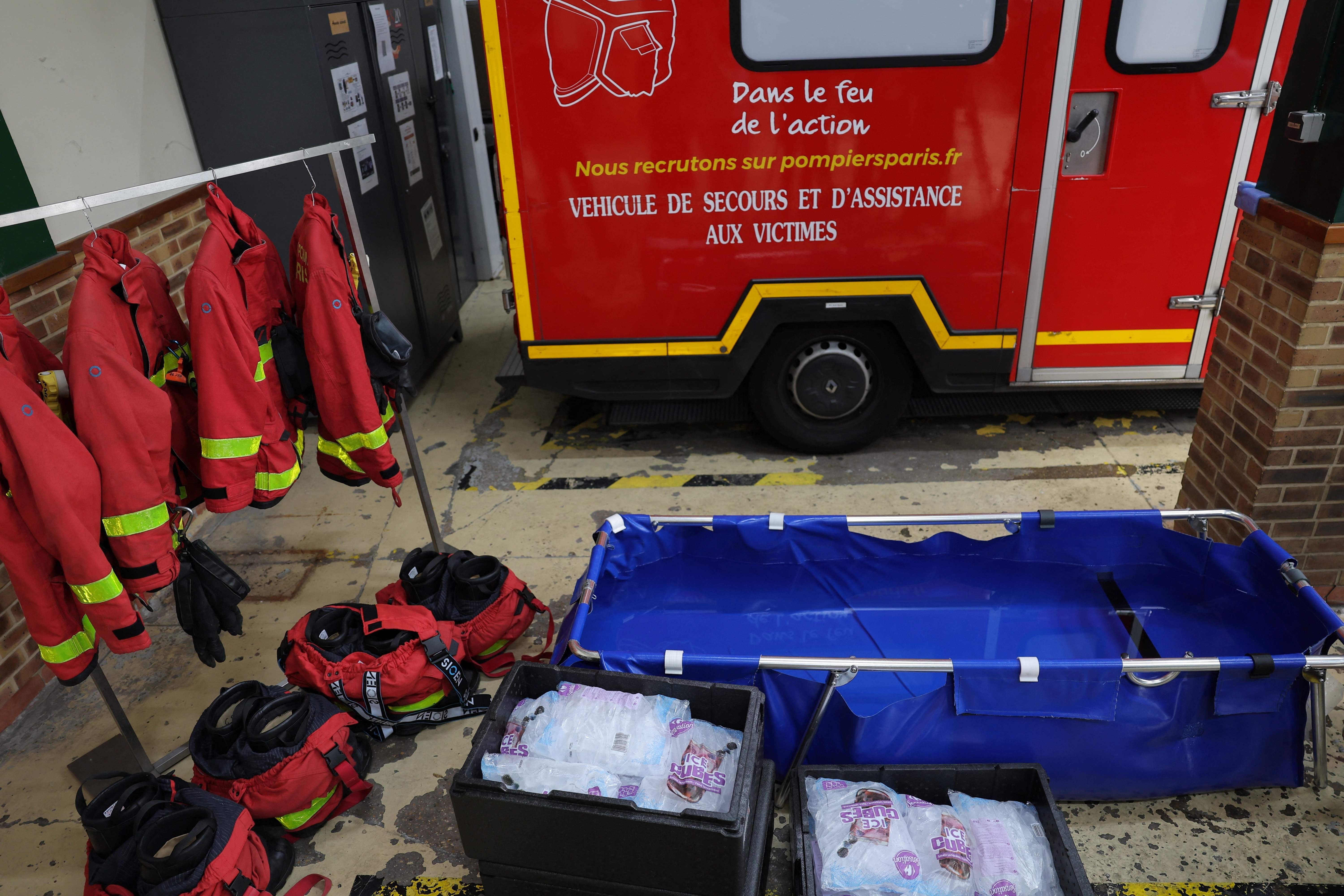 Feuerwehrschutzkleidung, Eisbäder und Eisbeutel vor einem Feuerwehrwagen in einer Pariser Wache.