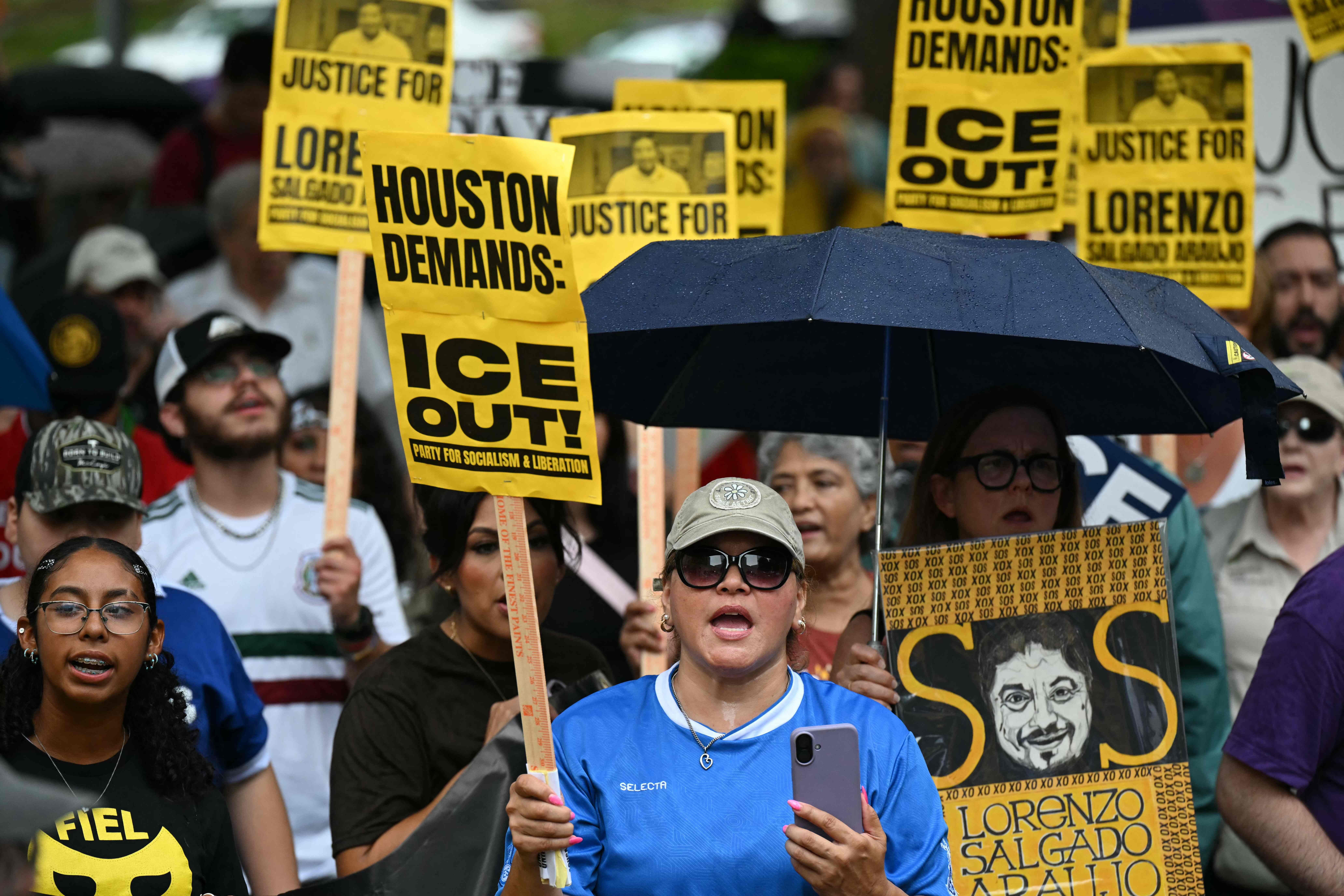 Demonstranten in Houston halten Schilder bei einem Protest gegen ICE und fordern Gerechtigkeit für Lorenzo.