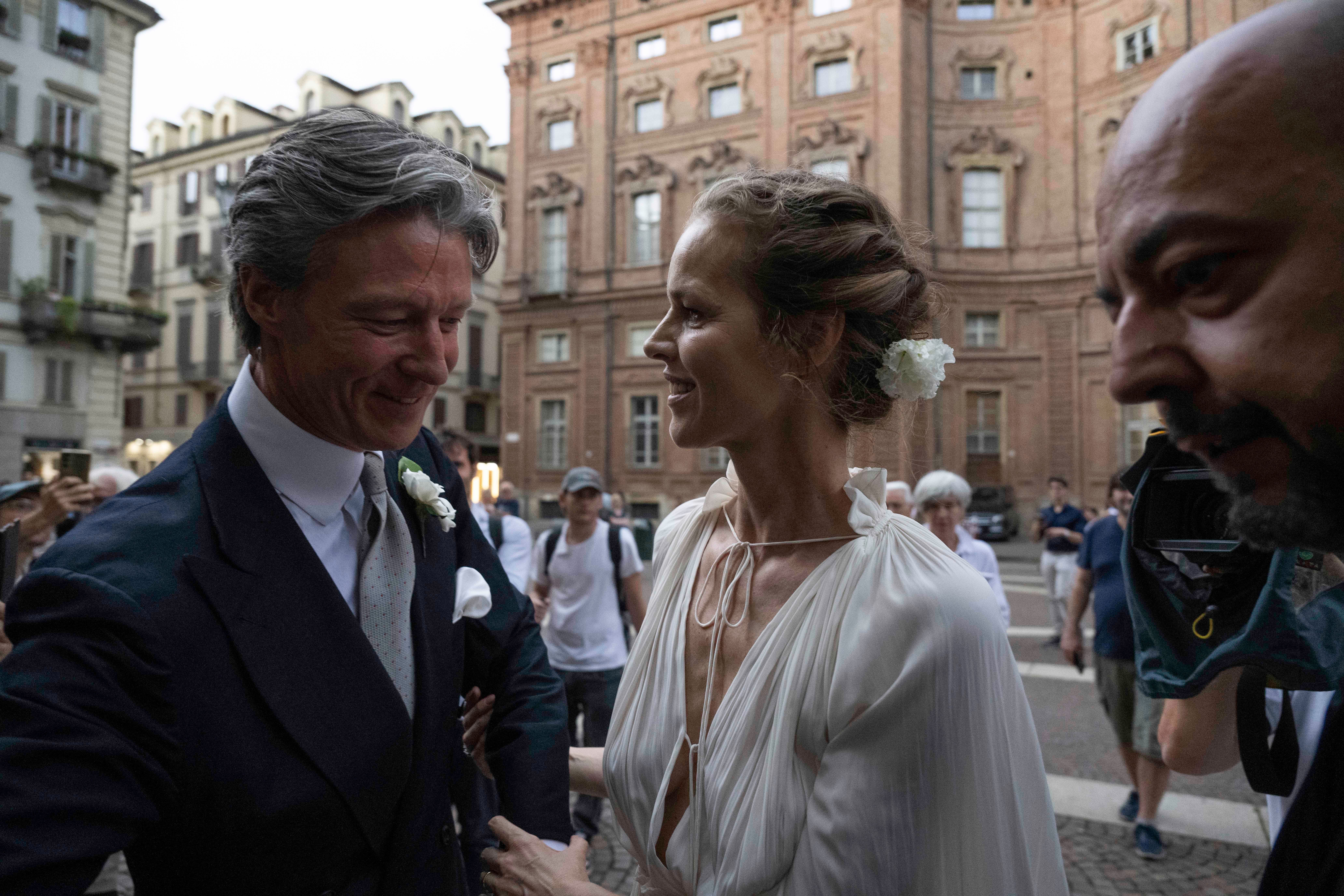 Braut und Bräutigam lächeln sich bei ihrer Hochzeit im Freien in einer Stadt an.