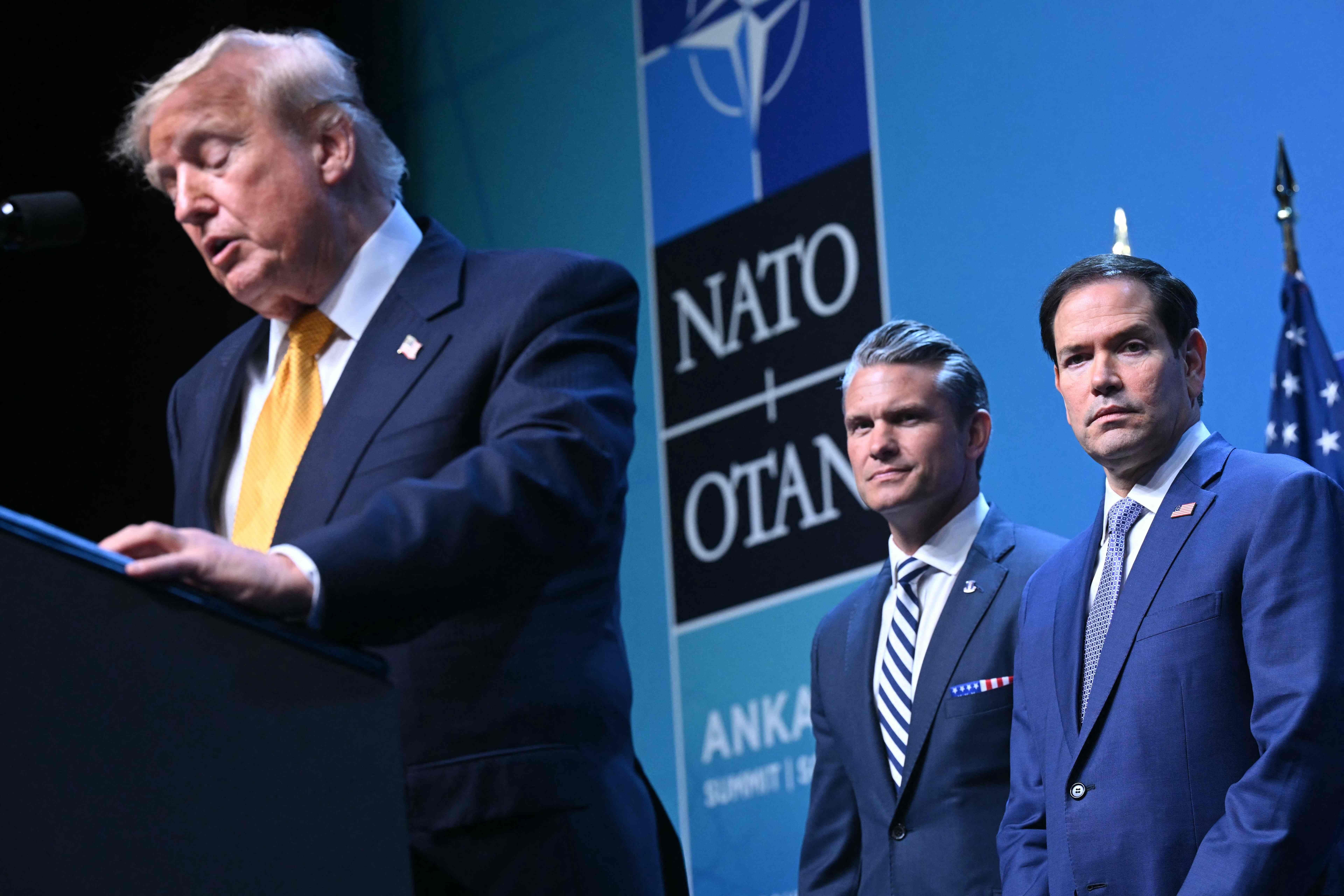 Drei Männer im Anzug bei einer Pressekonferenz während eines NATO-Gipfels in Ankara.