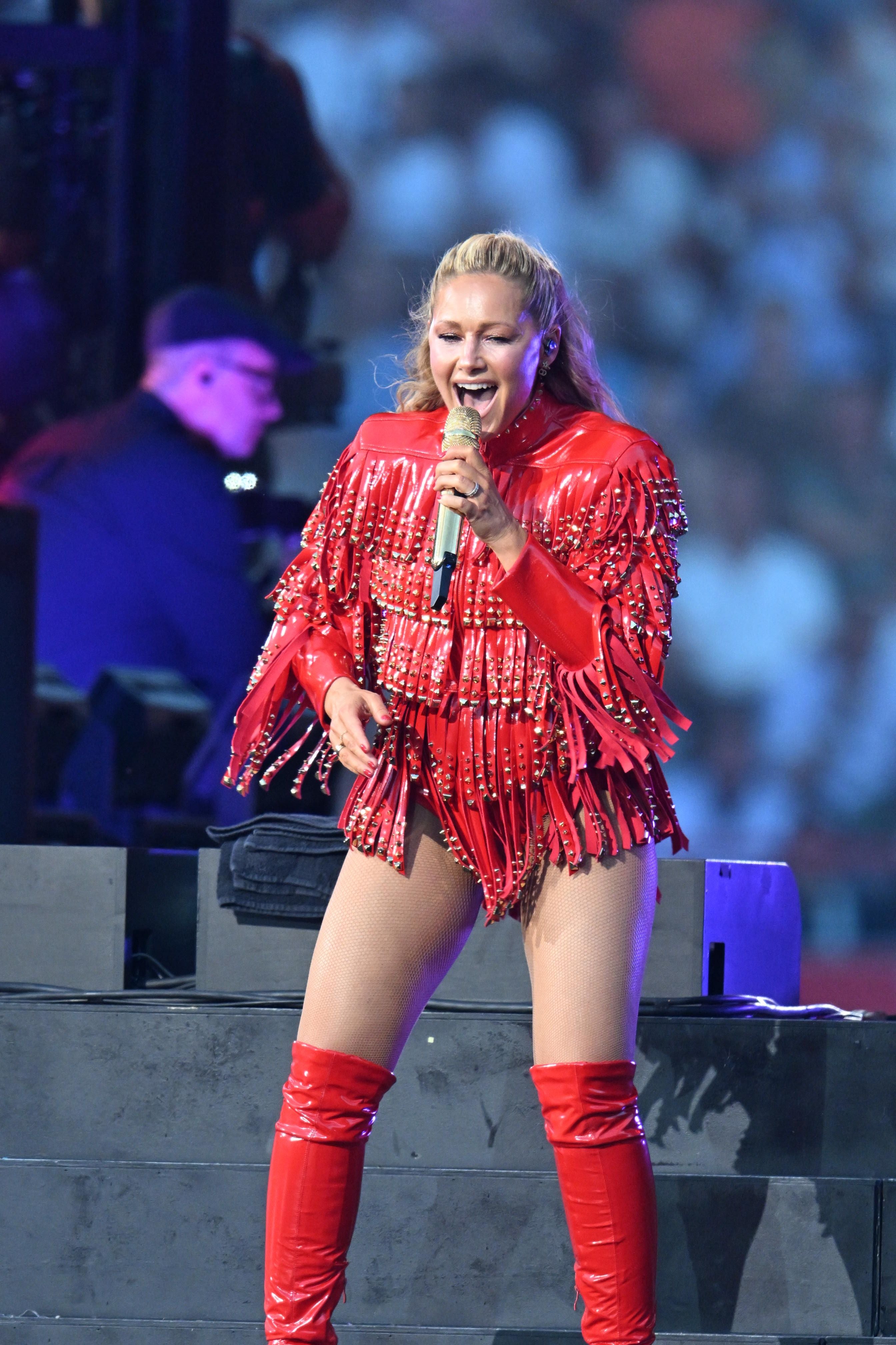 Frau in rotem Outfit singt mit Mikrofon auf Helene Fischer Konzert.