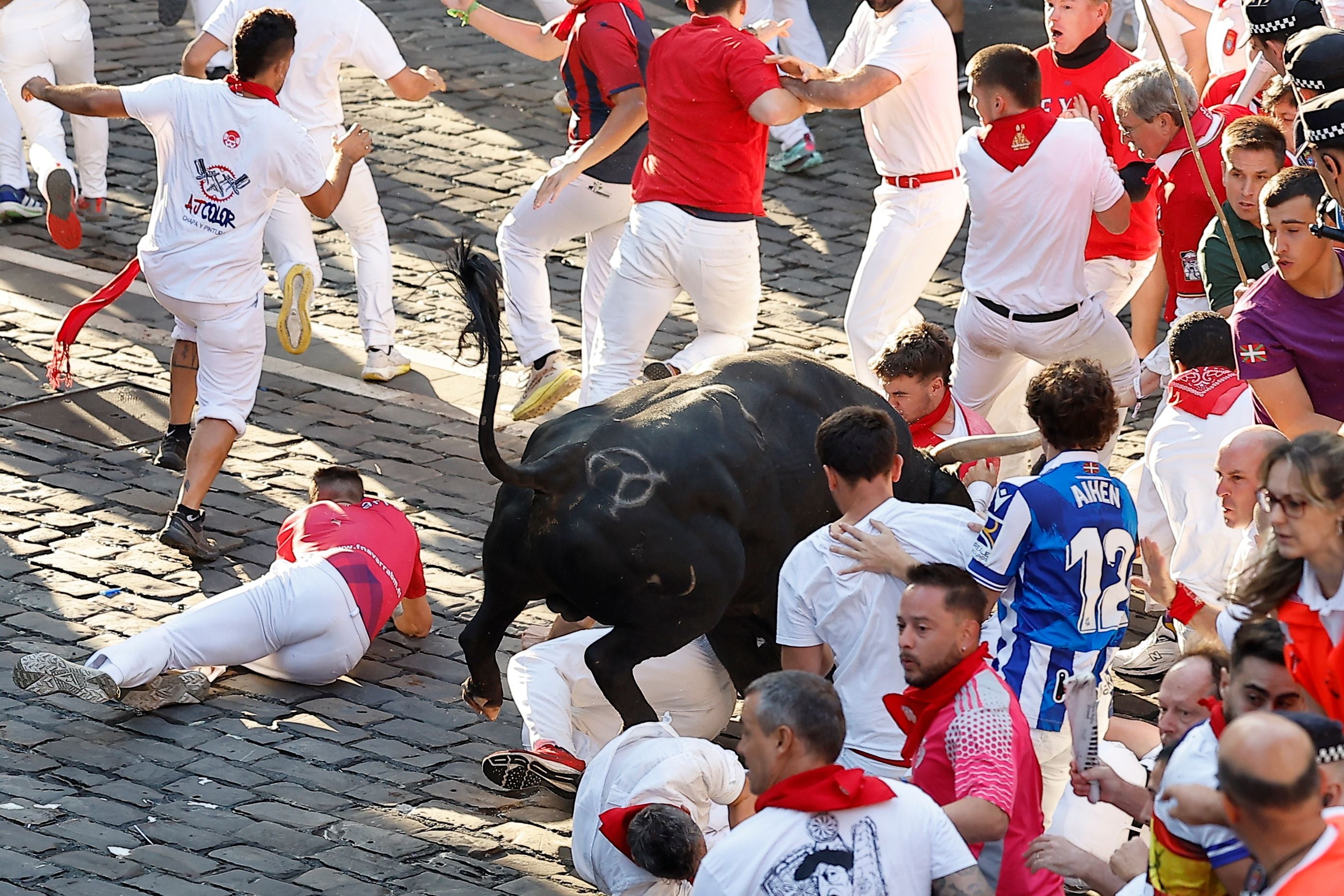 Ein Stier jagt eine Gruppe von Läufern während des Stiertreibens in Pamplona.