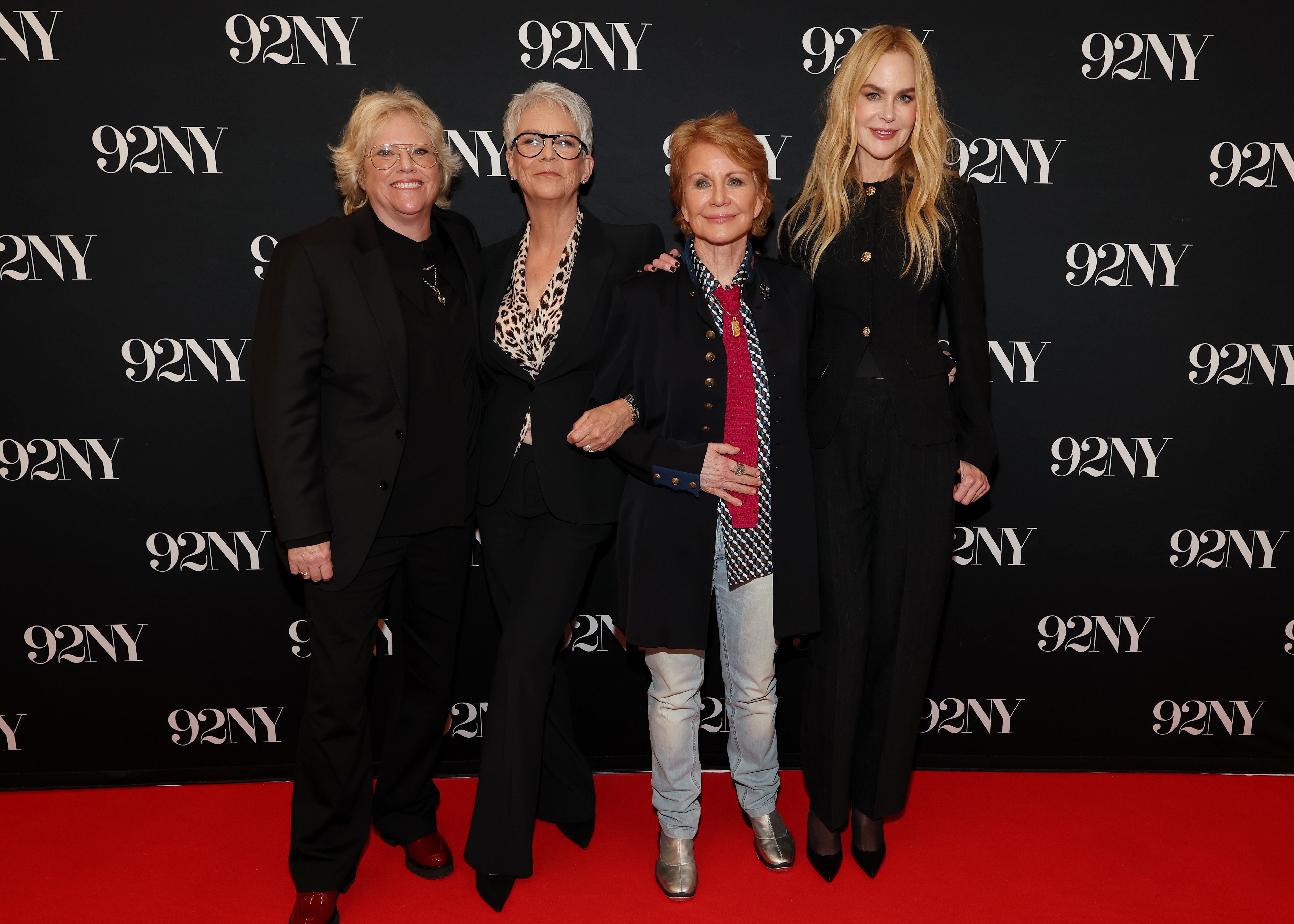 Vier Frauen posieren auf dem roten Teppich vor einer 92NY-Wand in New York.