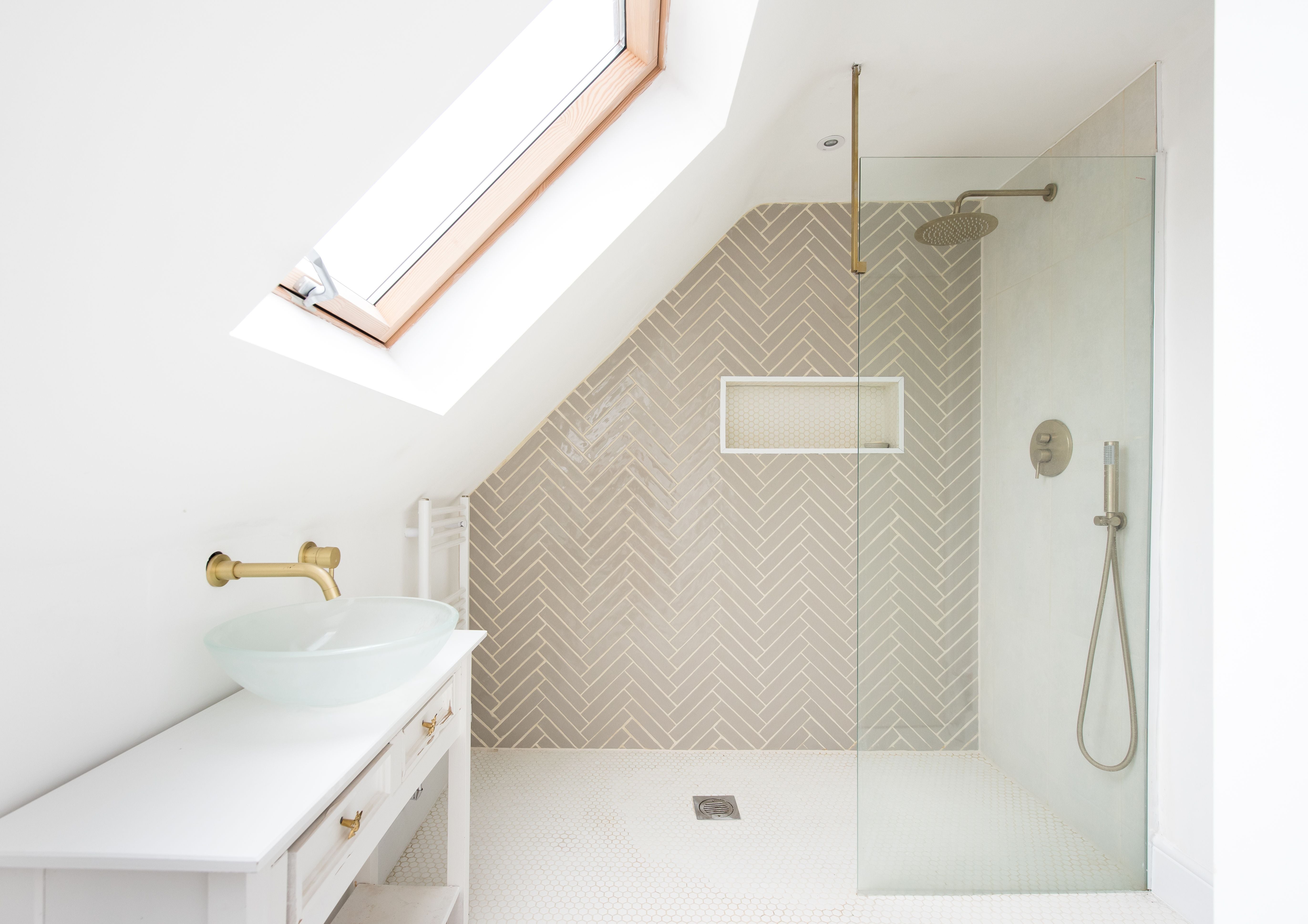 Helles Badezimmer mit Glaswaschbecken, Duschbereich, Dachfenster und modernen Armaturen.
