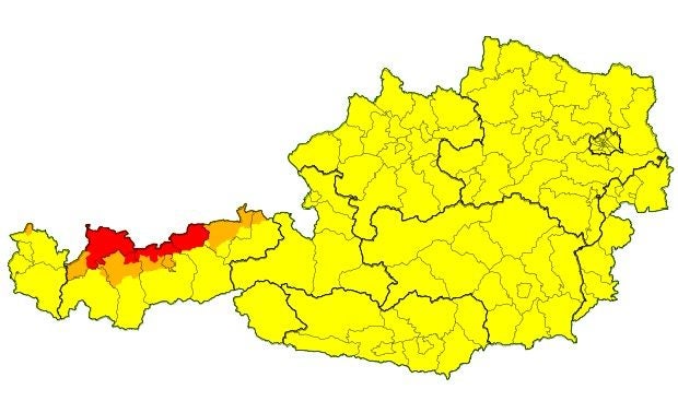 Unwetterkarte von Österreich mit roten und orangen Warnungen im Westen, sonst gelb.