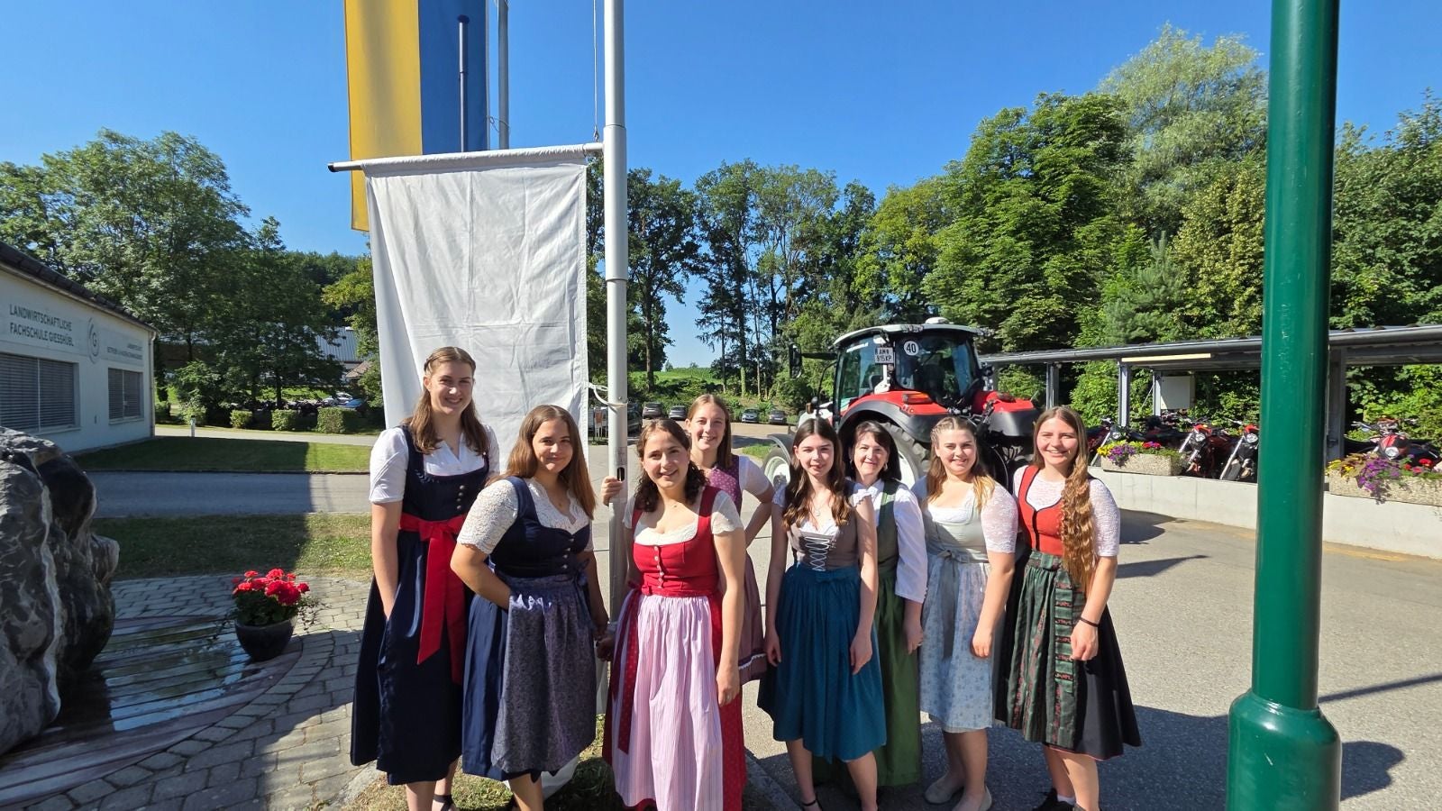 Acht junge Frauen in Dirndln stehen draußen vor der Fachschule Gießhübl.