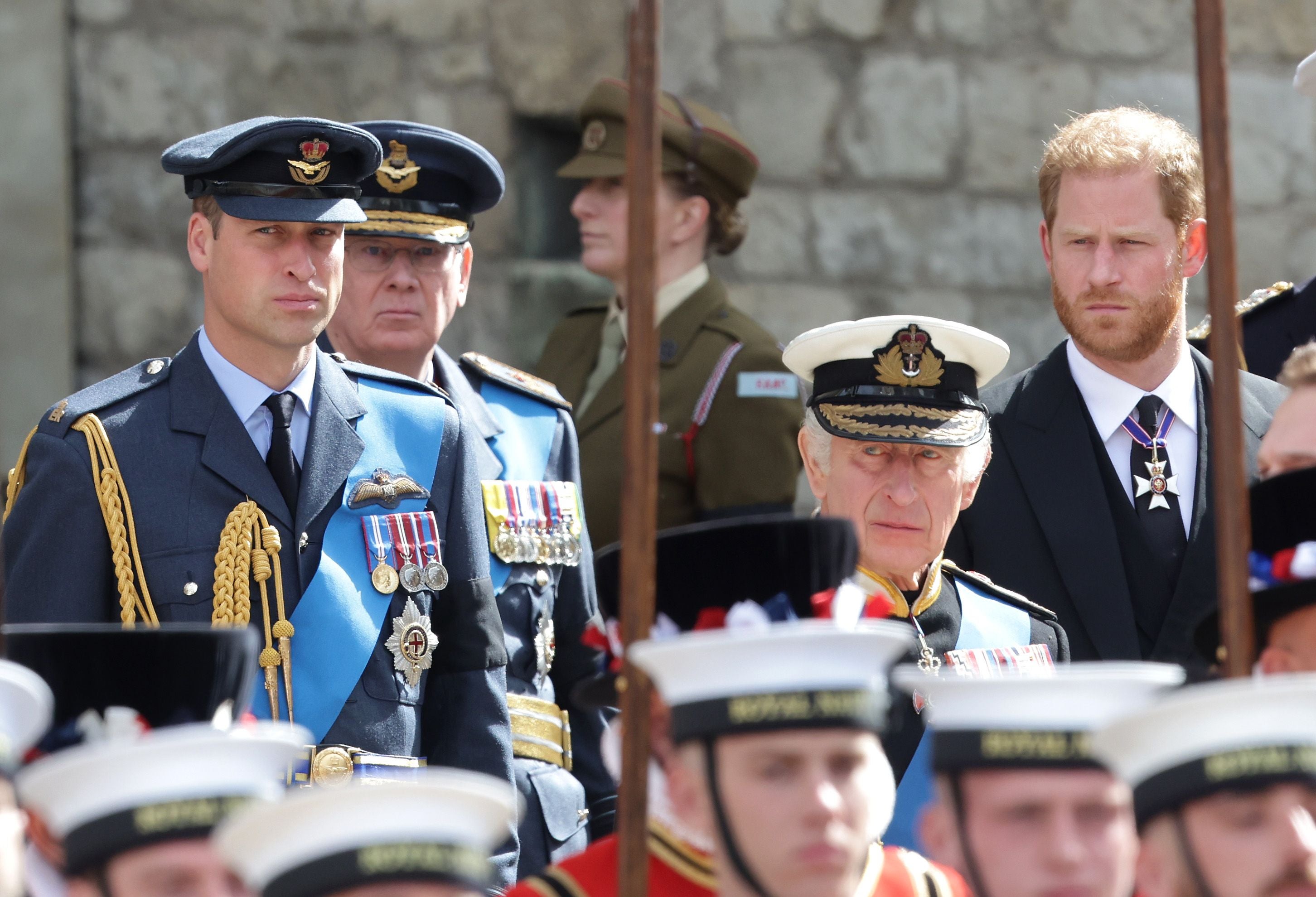 Mehrere Männer in Militäruniformen und ein Mann im Anzug bei einer offiziellen Trauerzeremonie.