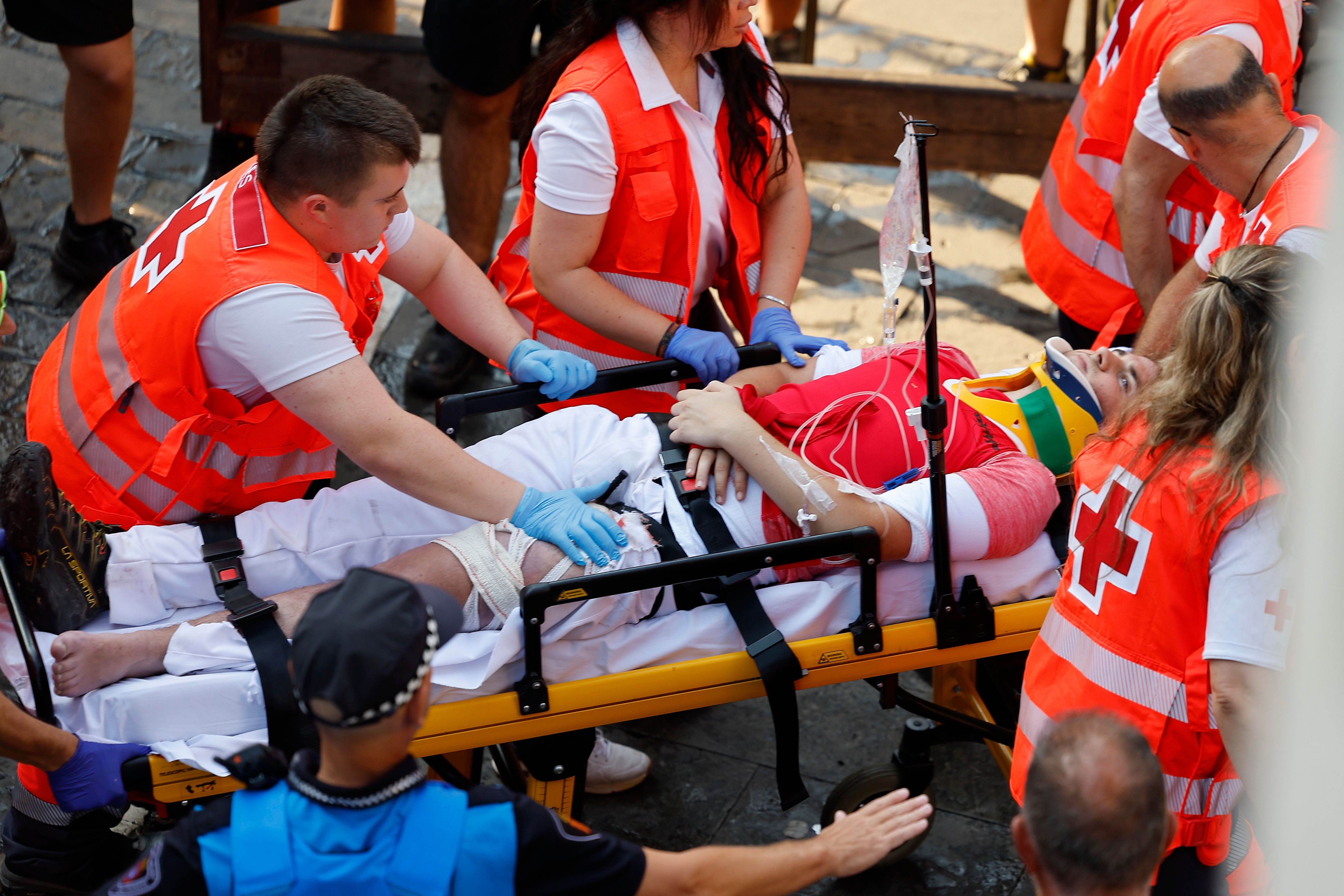 Sanitäter versorgen einen verletzten Läufer auf einer Trage beim San-Fermín-Festival in Pamplona.