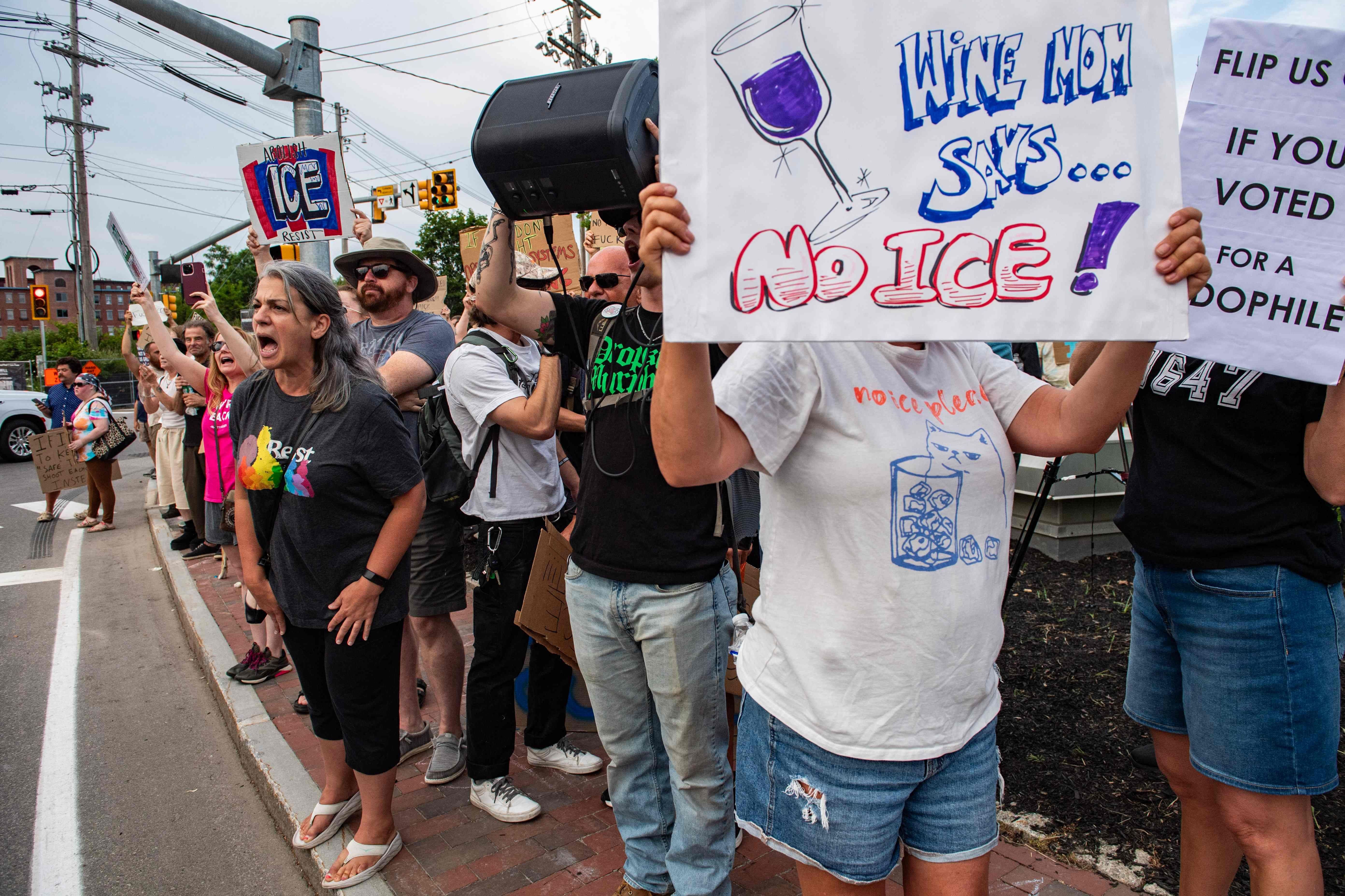 Demonstranten protestieren mit Schildern gegen ICE bei einer Mahnwache in Biddeford, Maine.
