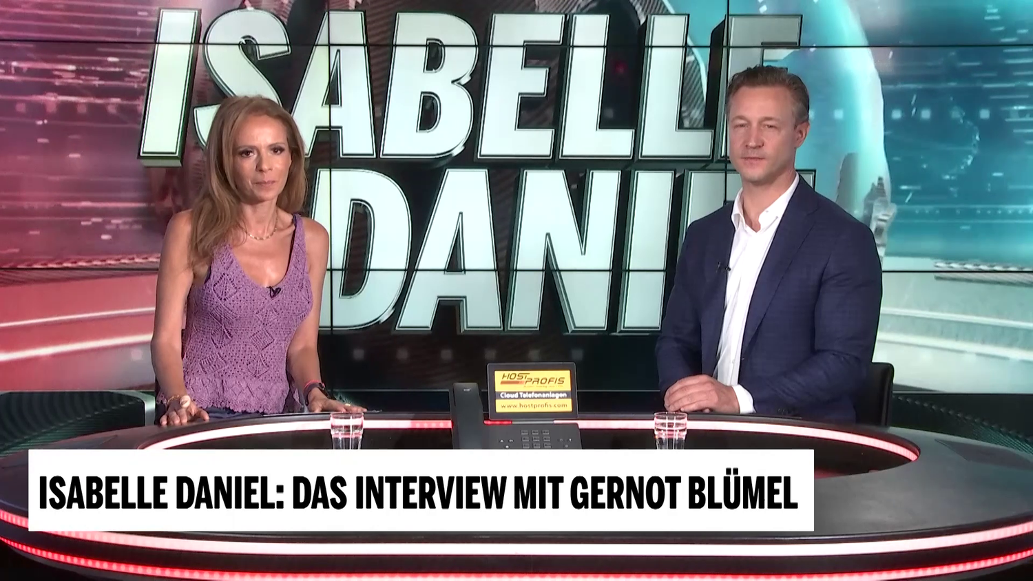Zwei Personen sitzen im Fernsehstudio für ein Interview mit dem Titel "Isabelle Daniel".